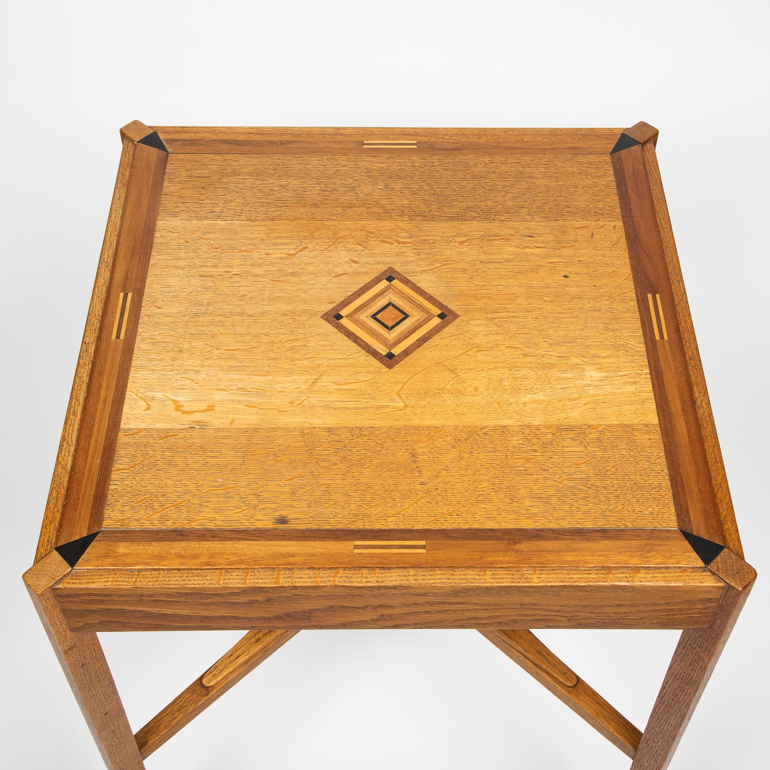 An early 20th century oak side table, with specimen inlaid geometric central design, English.