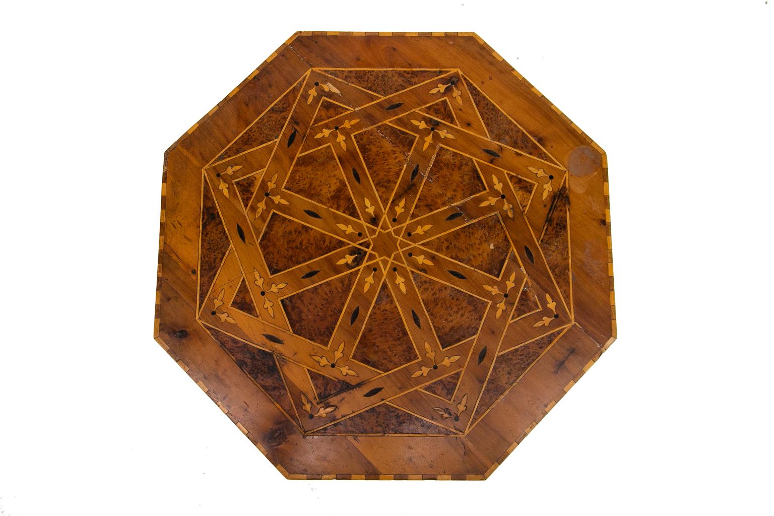 Inlaid octagonal table has a bird's-eye maple top inlaid with ebony, satinwood, and boxwood geometric inlays.
  