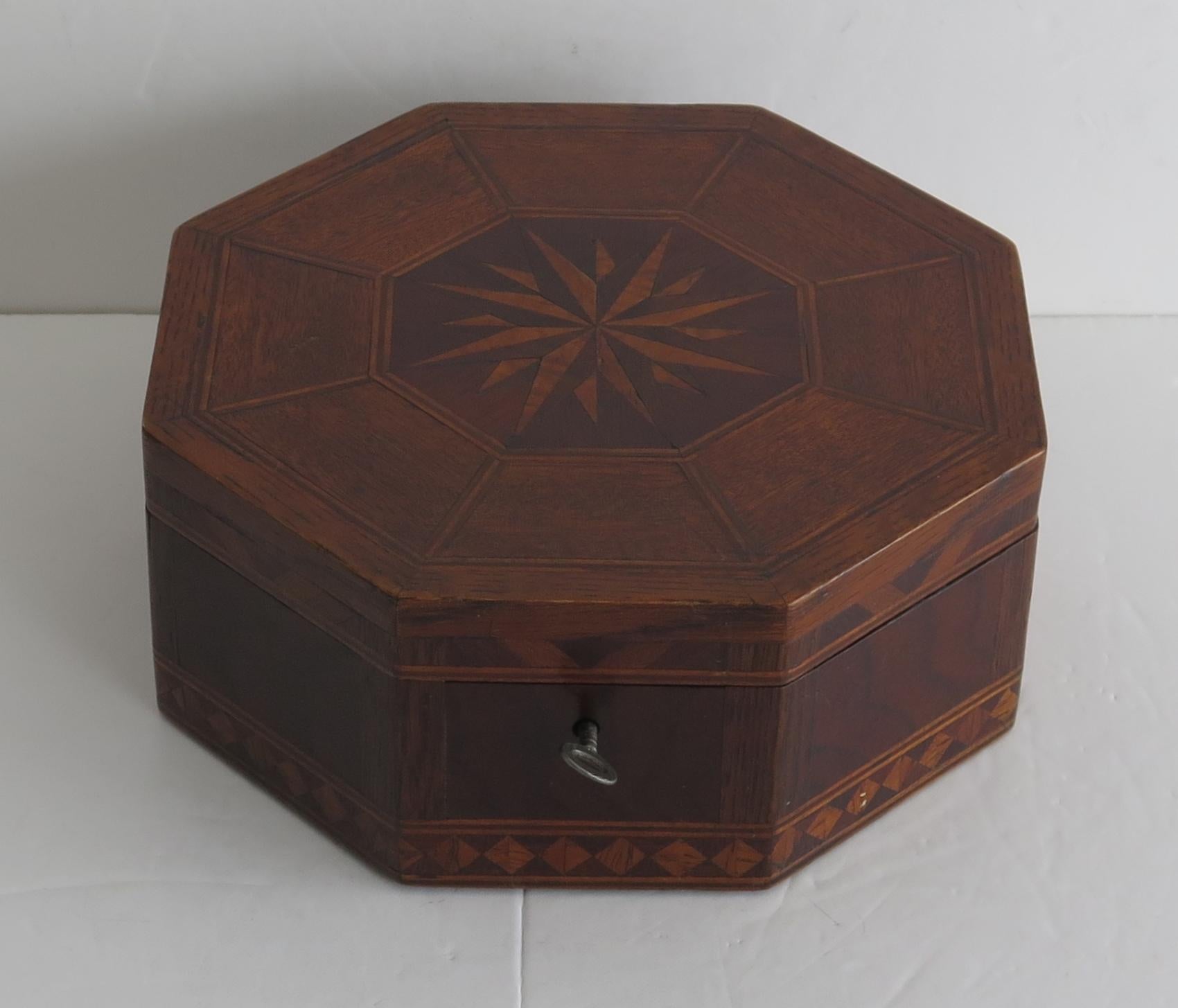 Dies ist eine wunderschön handgefertigte Eiche Sewing Box, der achteckigen Form mit eingelegten Sonnenschliff oben, voll ausgestattet innen und mit einem funktionierenden Schloss und Schlüssel, die alle aus ca. 1840.

Der Kasten hat eine achteckige