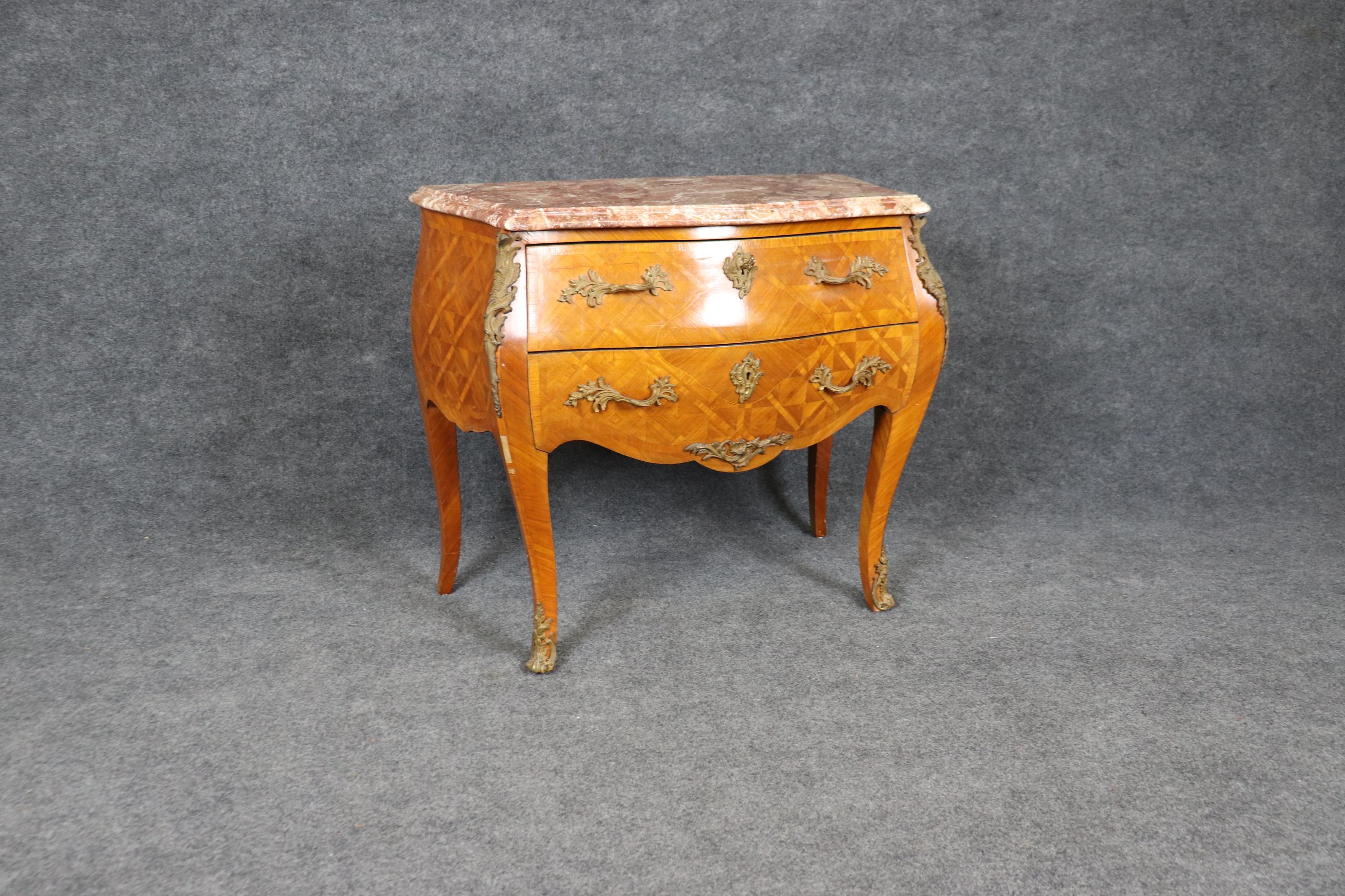 Si tratta di una splendida cassettiera a 2 cassetti realizzata in legno d'ulivo con una scanalatura incrociata e con un superbo piano in marmo di breccia. Il bronzo fuso è nitido e ben fatto. La cassa presenta alcune piccole perdite di