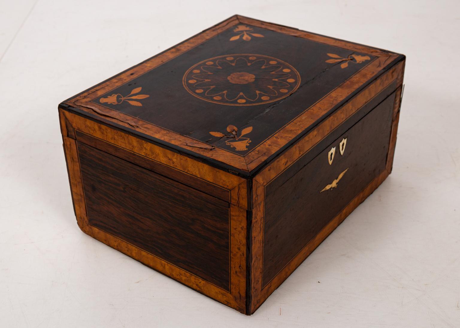 Rosewood jewelry or sewing box with satinwood, bird's-eye maple, and bone inlay, circa 1830s. The veneered piece features an interior fitted with compass rose inlay. Please note of wear consistent with age including cracks, minor losses, and
