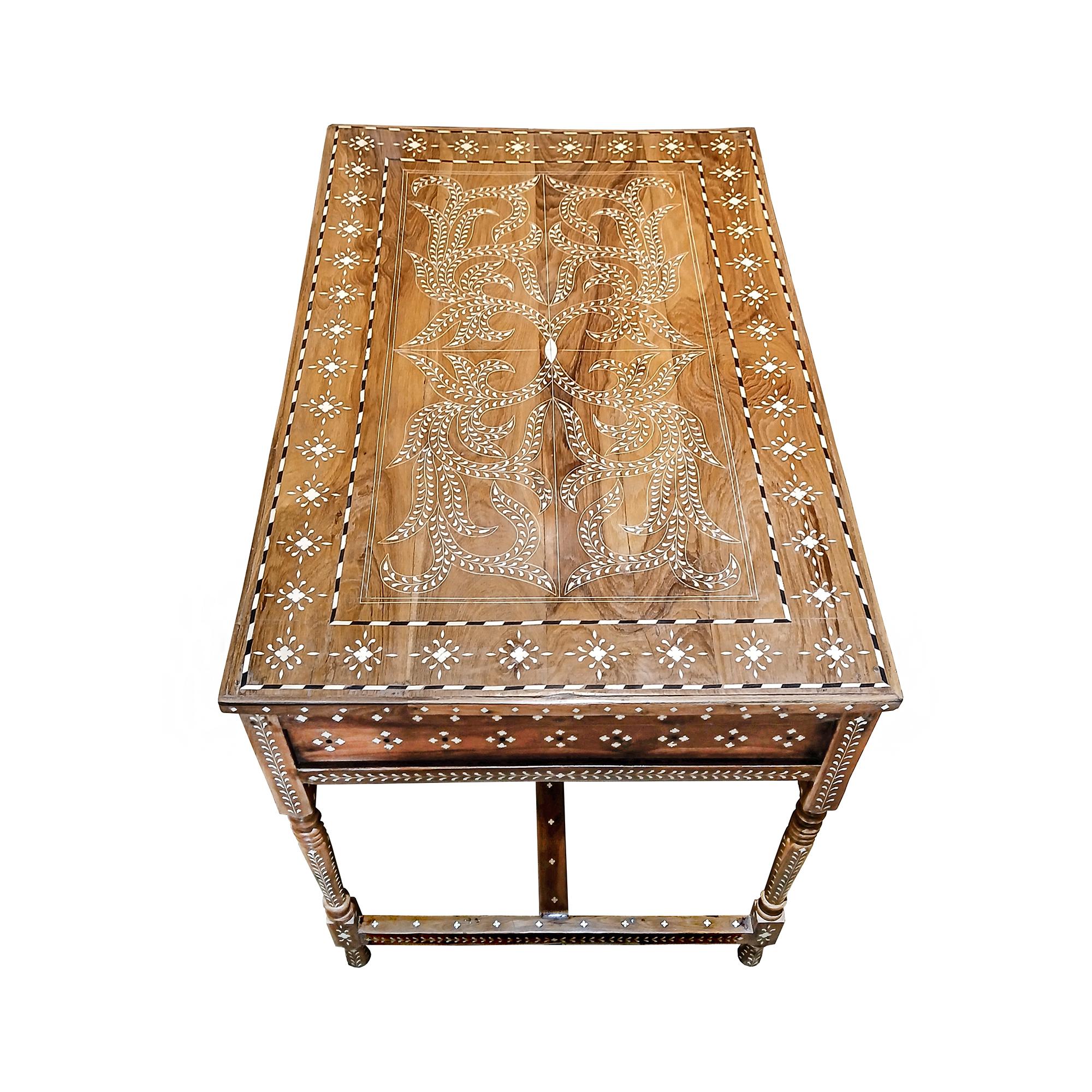 A beautiful writing desk, handcrafted in India out of aged teak wood and responsibly sourced animal bone inlay. Late 20th Century (1990-1995).  Split front apron, two drawers with bronze pulls,  bottom stretchers in H pattern, two vertical and one