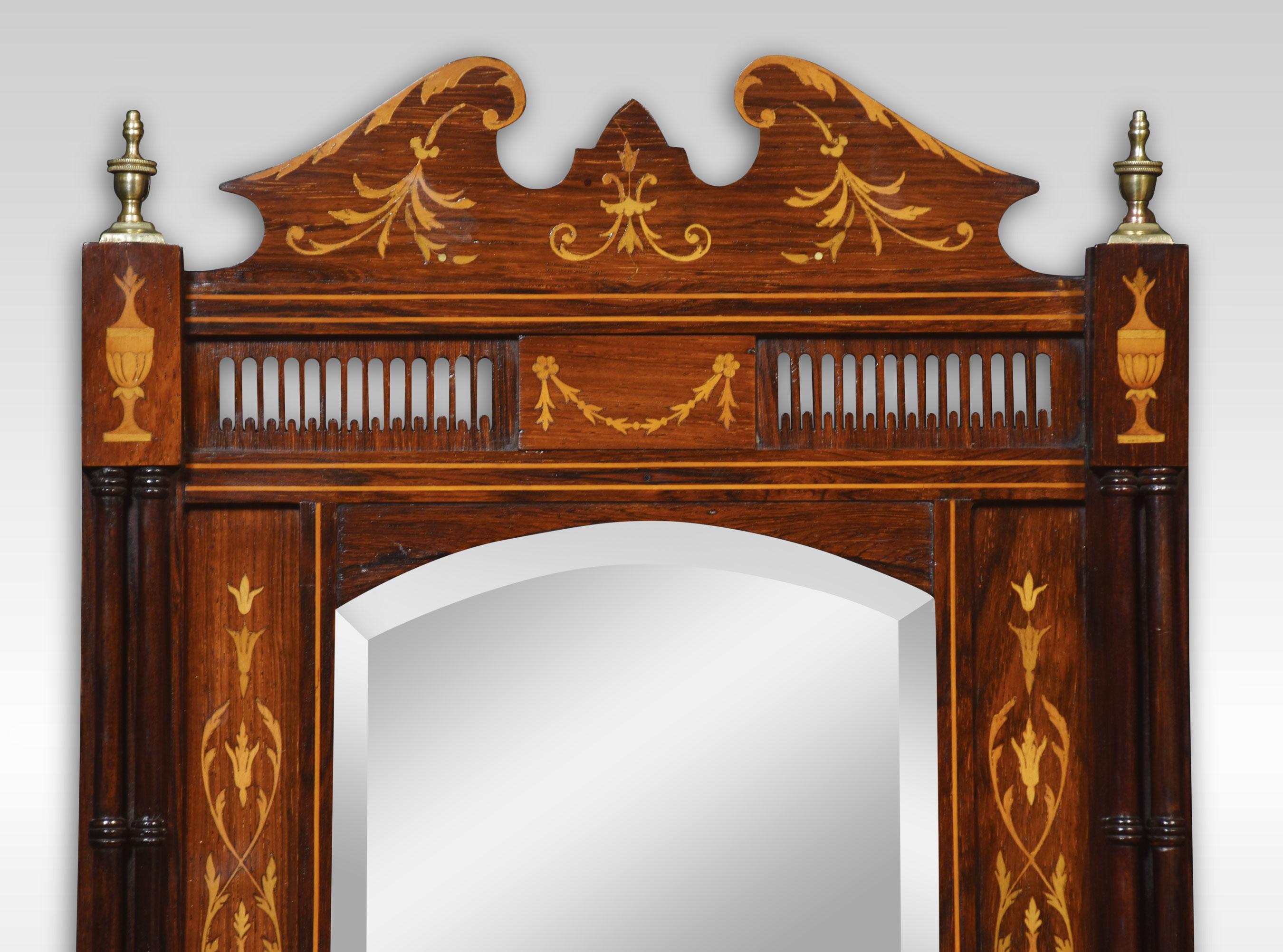 Wall mirror, the molded pediment with scrolling inlaid detail,flanked by brass urn capitals and similar inlaid urns bellow supported on turned colums. To the original beveled mirror plate encased in rosewood frame. Above bow fronted shelf with