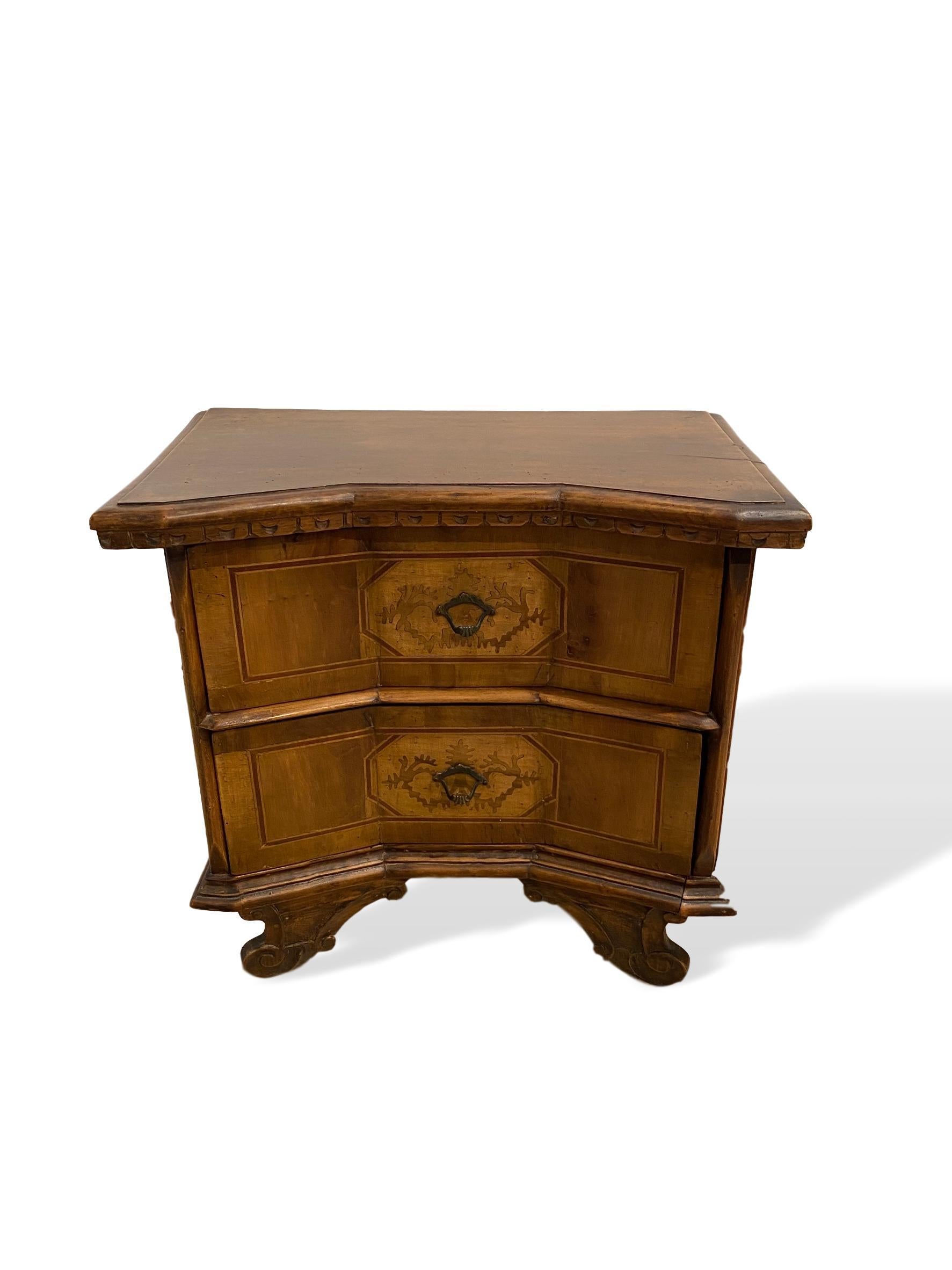Inlaid walnut two-drawer side commode with concave block front, Italian, circa 1900, with shaped, molded top and half moon carved dentil molding below, with highly desirable concave blocked front, with inlaid satinwood geometrical central inlays