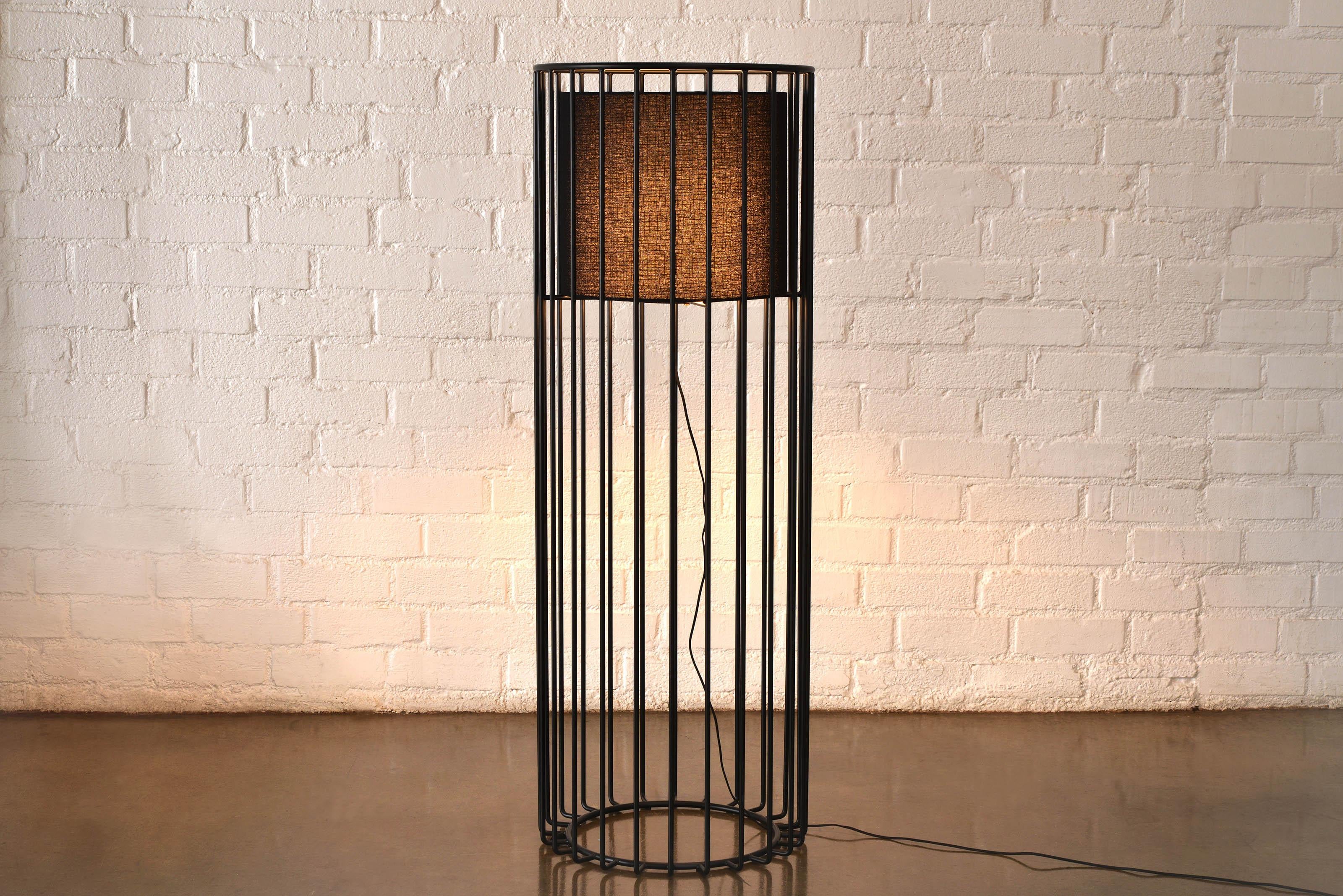 Inner Beauty Floor Light di Phase Design
Dimensioni: Ø 50,8 x H. 142,2 cm. 
Materiali: Lino nero e metallo verniciato a polvere.

Barra in acciaio massiccio disponibile con verniciatura a polvere in ottone fumé, cromo lucido, rame bruciato, nero
