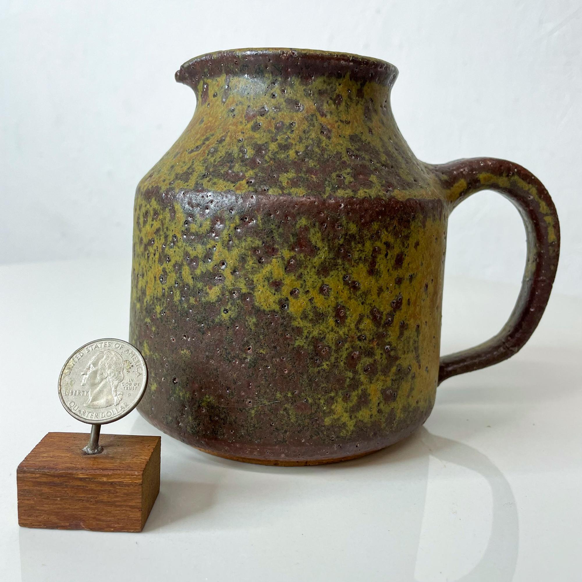 Mid-Century Modern muted yellow and brown glazed pottery jug after designs of Doyle Lane USA 1960s
In crackling topography wonderful textured appearance.
Artist signed, unclear signature.
Measures: 6.25 D x 4.75 H x 5.25W diameter inches
Refer