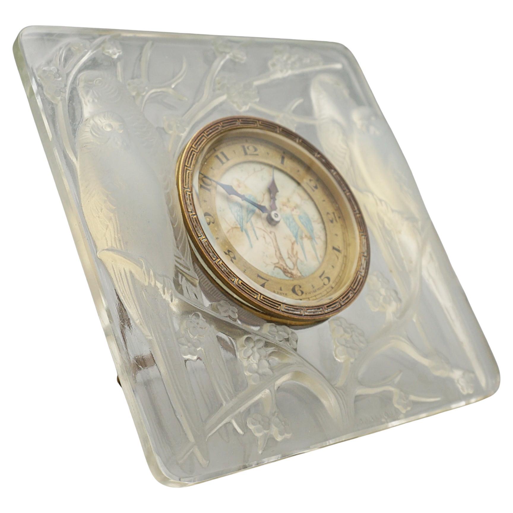 Inséparables, un orologio in vetro Art Déco di Rene Lalique (1860-1945). Modellato in rilievo con due coppie di inseparabili blu opalescenti seduti su fiori di pruno. Quadrante smaltato dipinto a mano che raffigura una scena di fiori e uccelli