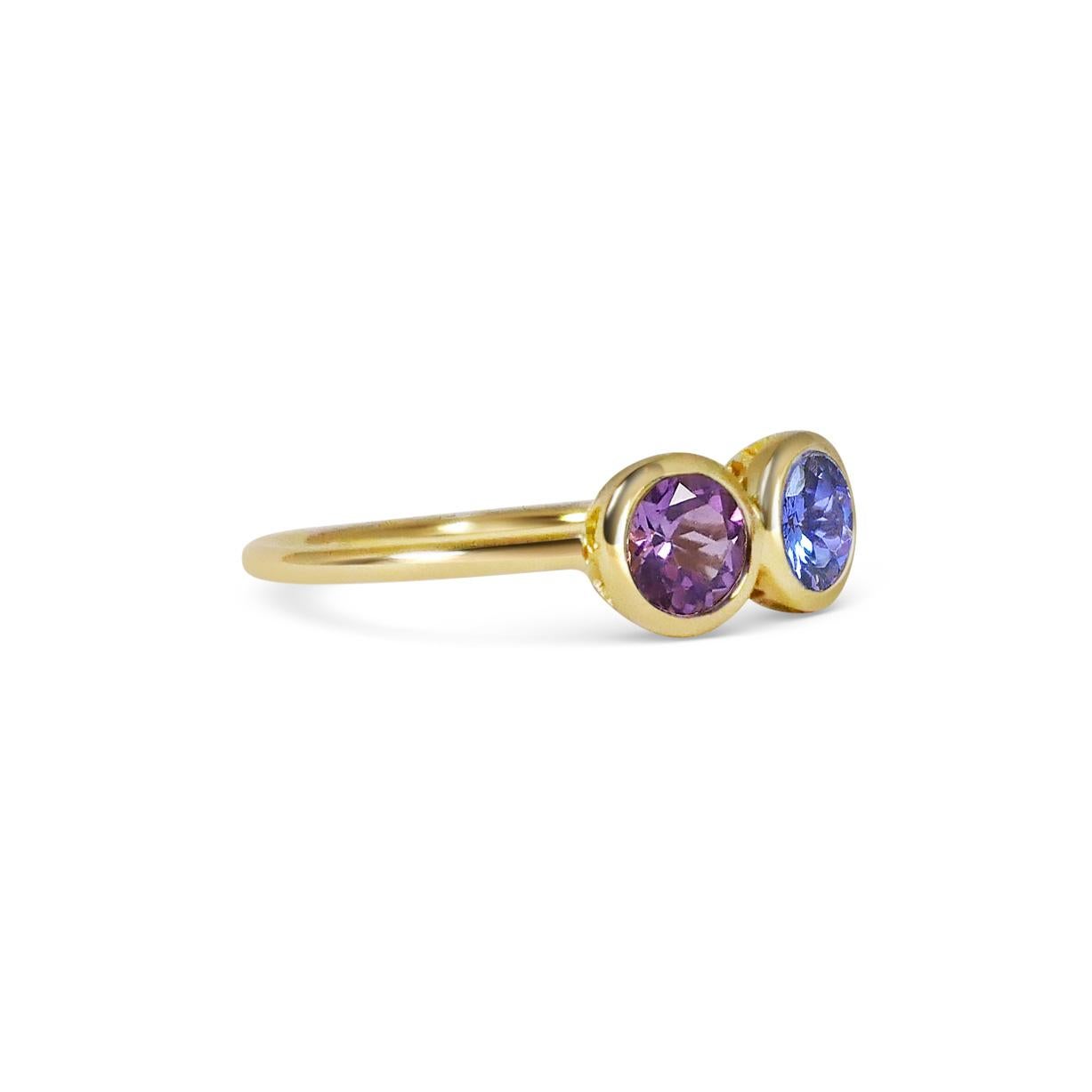 Matching stones together is one of Anna's favorite part of the design process. Here she has carefully matched a beautiful ink blue Tanzanite next to a deep purple Amethyst for their strong and vibrant hues. Set in 18k yellow gold to compliment and