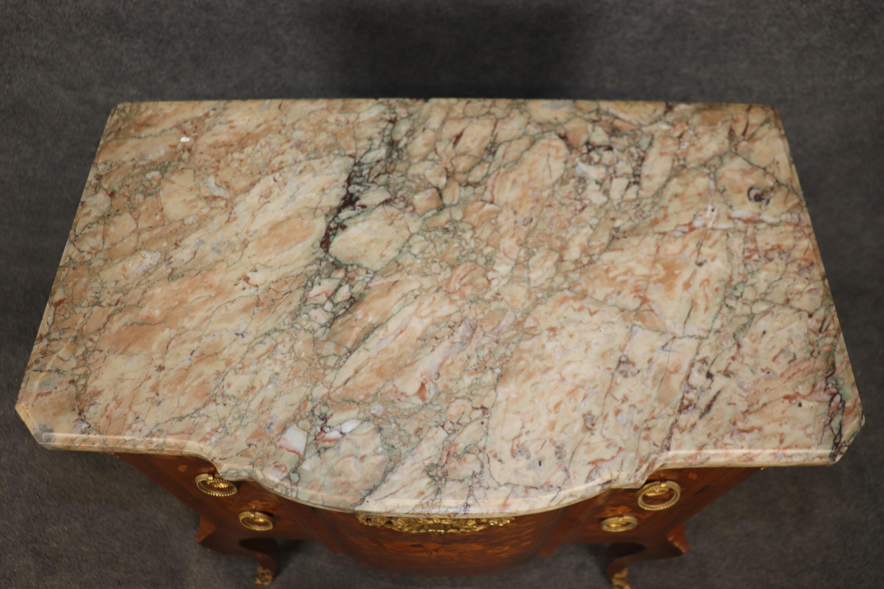 This is a superb, inlaid commode signed by Dieudonne of Paris. The piece is beautifully inlaid with sheet music and a mandolin and a fantastic assortment of mixed woods and marble on top. The beautiful gold Dore' finish is the Coup de grâce to an
