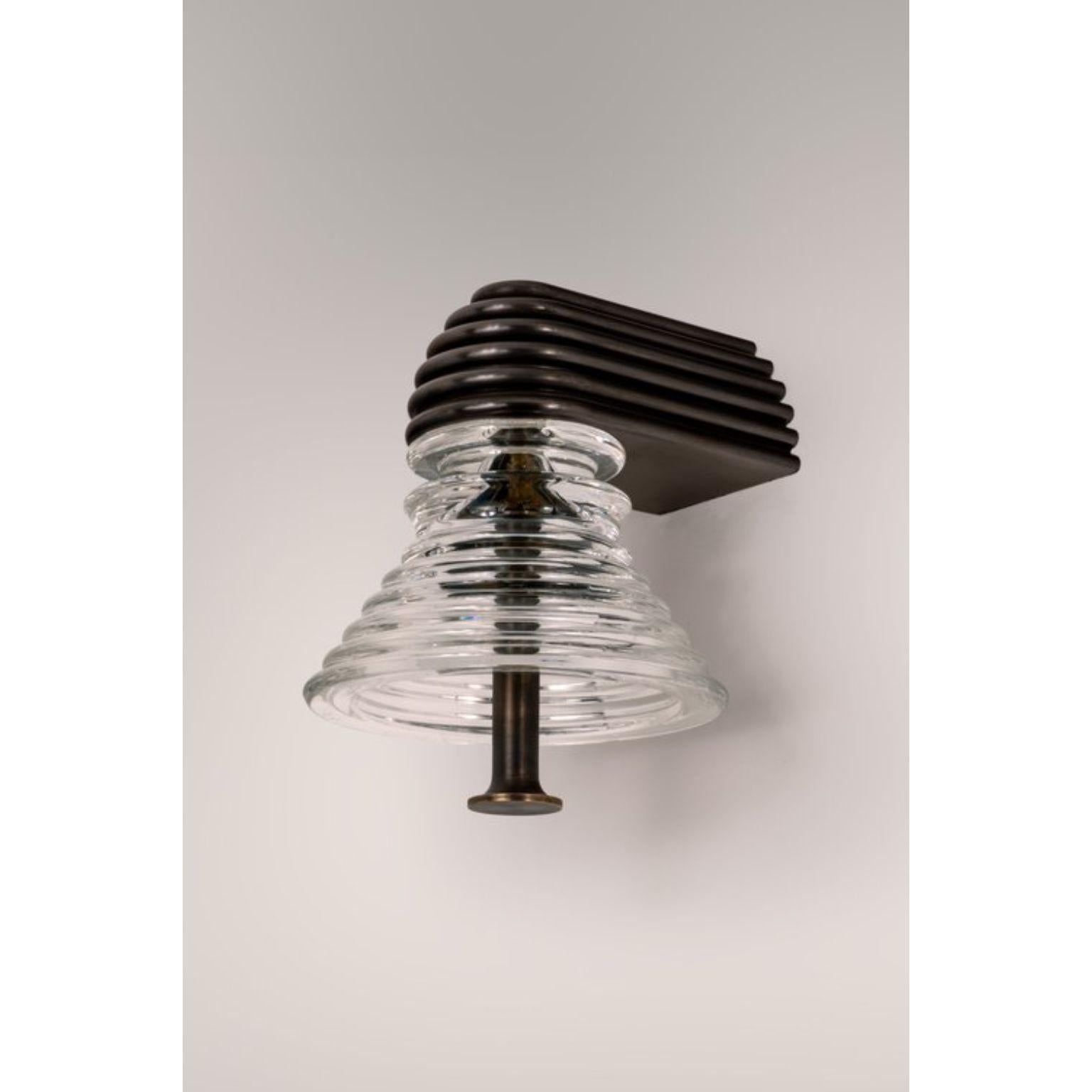 Insulator A Clear Glass and Dark Brass Sconce by Novocastrian
Dimensions: Ø 14 x H 21 cm.
Materials: Clear glass and dark brass.  

All products are available in custom dimensions and finishes. Rods can be cut to length or provided at longer lengths