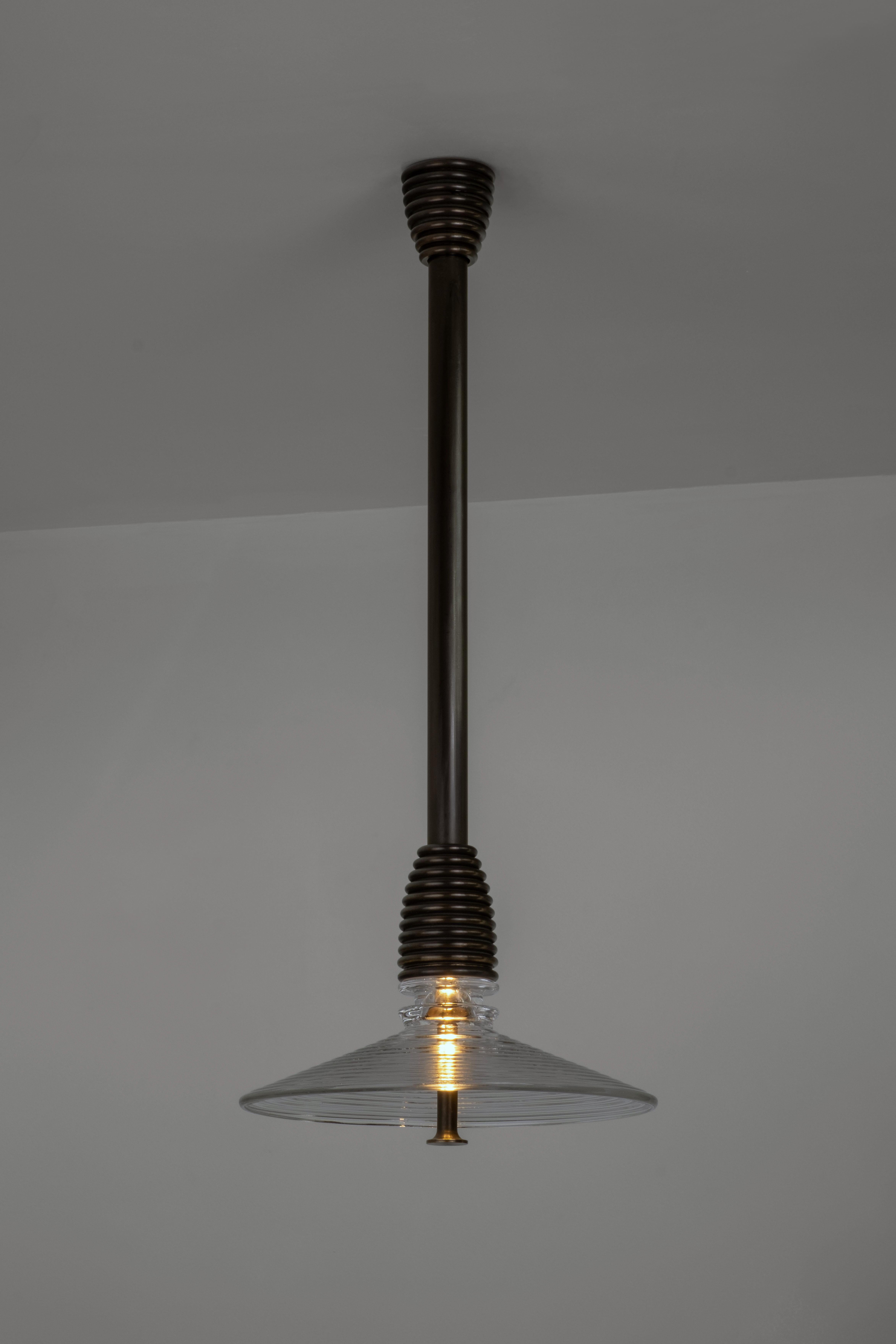 Ciondolo Insulator B in vetro trasparente e ottone scuro di Novocastrian
Dimensioni: Ø 32 x H. 21 cm. Lunghezza dell'asta: 85 o 125 cm.
Materiali: Vetro trasparente e ottone scuro.  

Tutti i prodotti sono disponibili in dimensioni e finiture