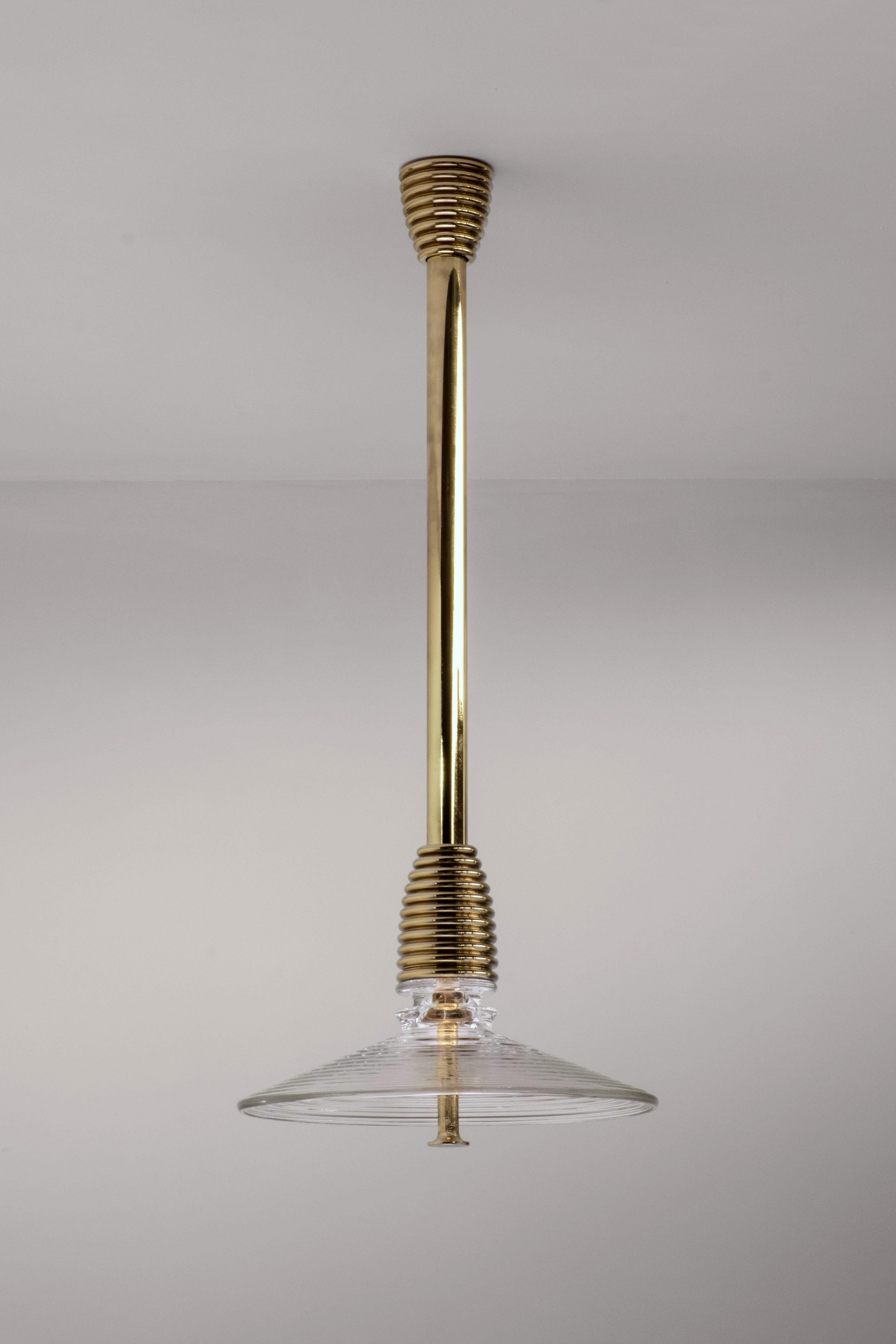Insulator B Clear Glass and Polished Brass Pendant by Novocastrian
Dimensions: Ø 32 x H 21 cm. Rod lenght: 85 or 125 cm.
Materials: Clear glass and polished brass.  

All products are available in custom dimensions and finishes. Rods can be cut to