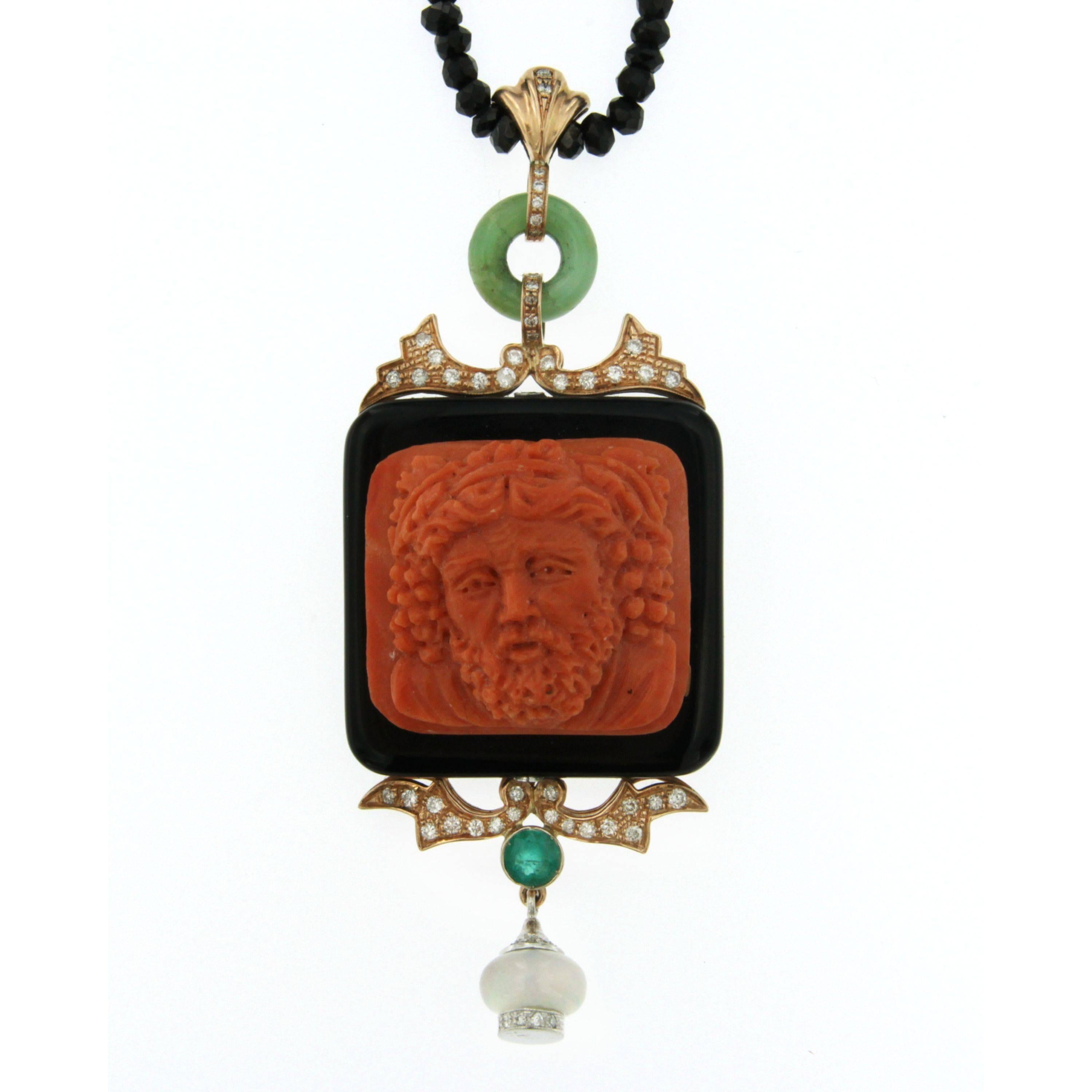 Pendant necklace in 14kt rose gold. It is composed of Mediterranean Coral carved classical male face surrounded by an onyx frame and embellished with diamonds, emerald and jade. Onyx chain 44 cm long (17.32 inches)
The craftmanship on this pendant