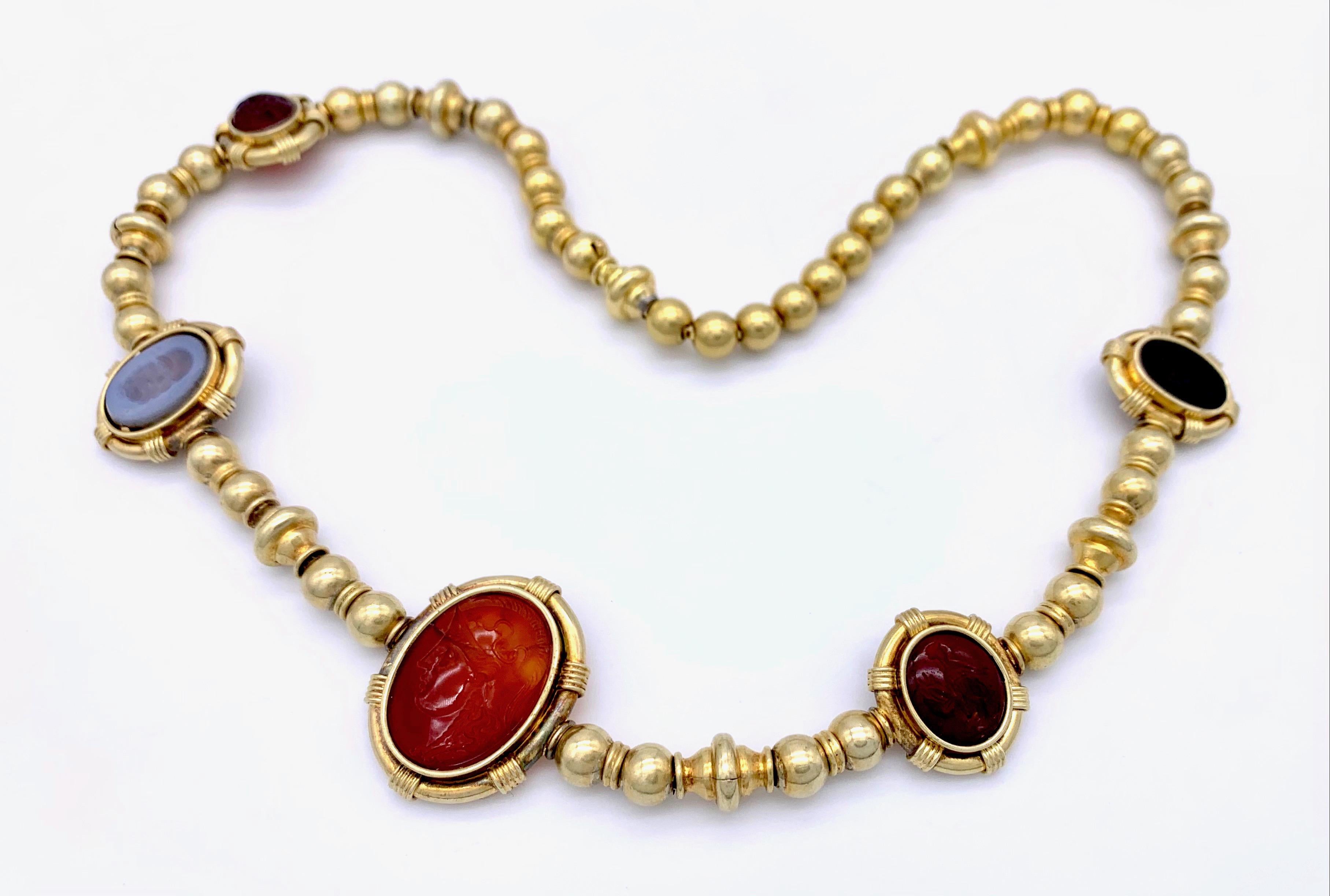 Five agate intaglios of varying size and age have been mounted in 18 karat gold settings. The settings are connected by golden balls made out of 18karat .
They are threaded on a foxtail chain.
The intaglios from left to right feature a sitting