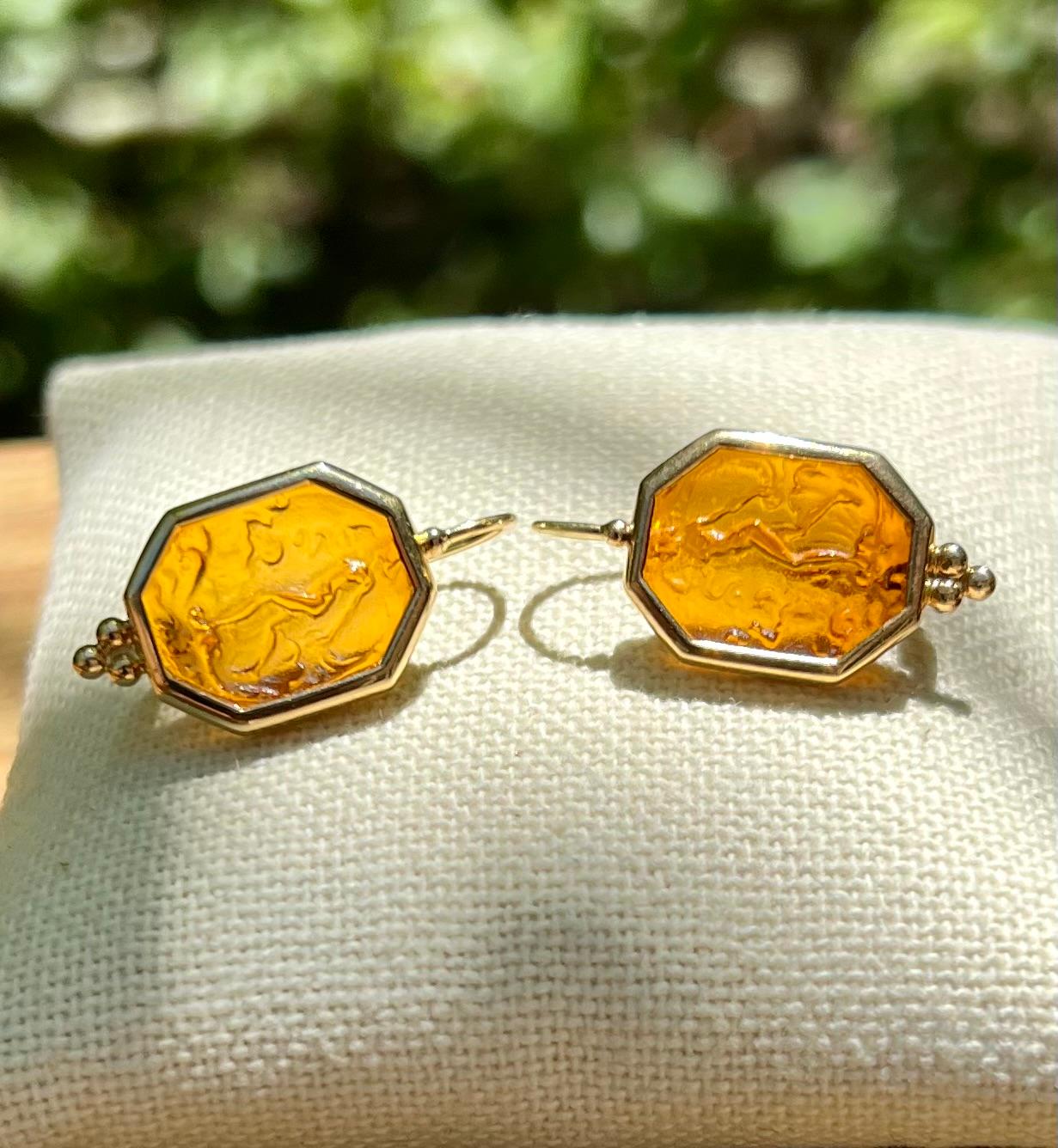 Un par de pendientes de oro amarillo de 14 quilates (estampado 585), de resina fundida de inspiración renacentista, engastados en bisel, de mujer desnuda calada.  Los pendientes miden 16 x 12 mm, pesan 6,3 gramos y se completan con cierres de