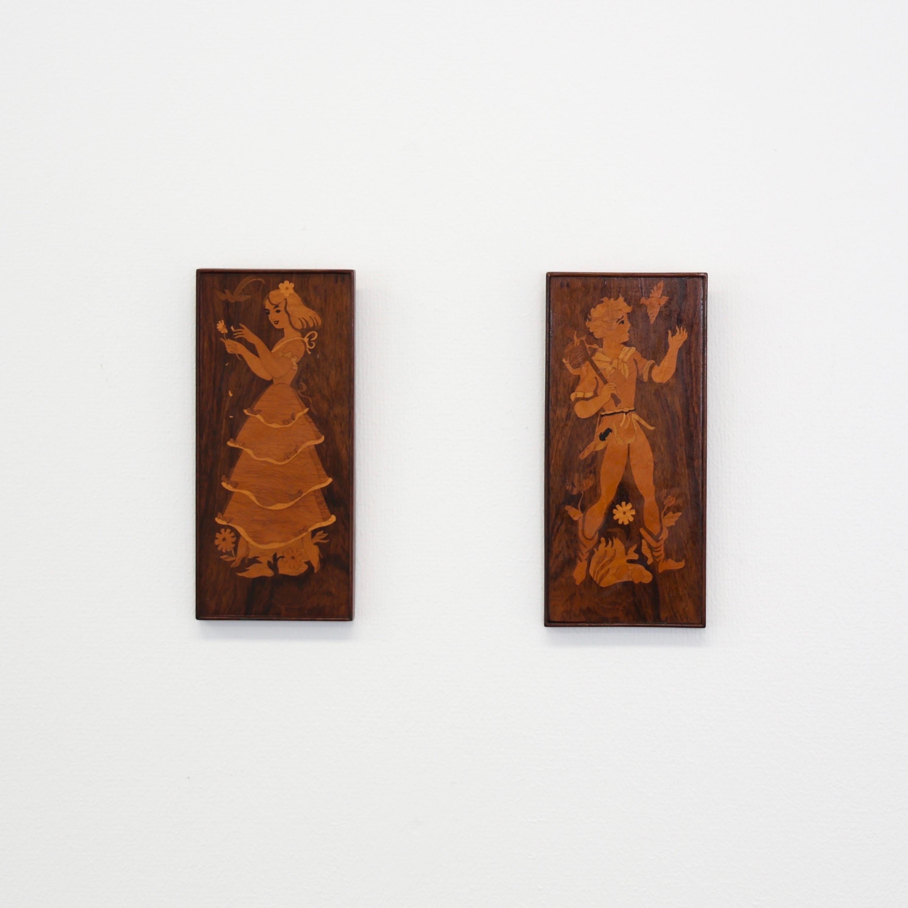 Ensemble de pièces murales en intarsia fabriquées par Mjölby Intarsia, vers les années 1950. 

* Ensemble (2) de pièces murales en intarsia représentant une fille et un garçon. 
* Fabricant : Mjölby Intarsia
* Année : est. 1950s. 
* Condition : Etat