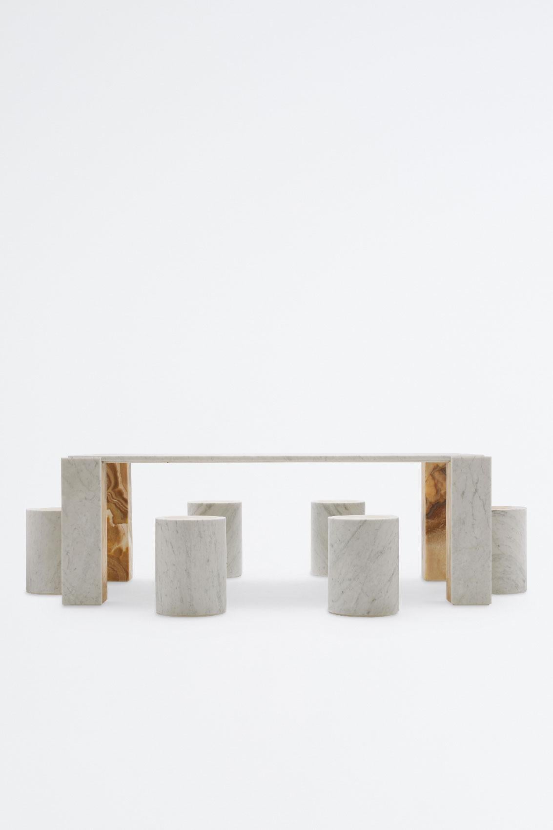Table unique en Carrara blanc avec des marquetteries en onyx miel comme supports pour les objets à poser. L'onyx miel est également présent sur la face interne du pied. La table est le fruit de la collaboration entre les directeurs artistiques de