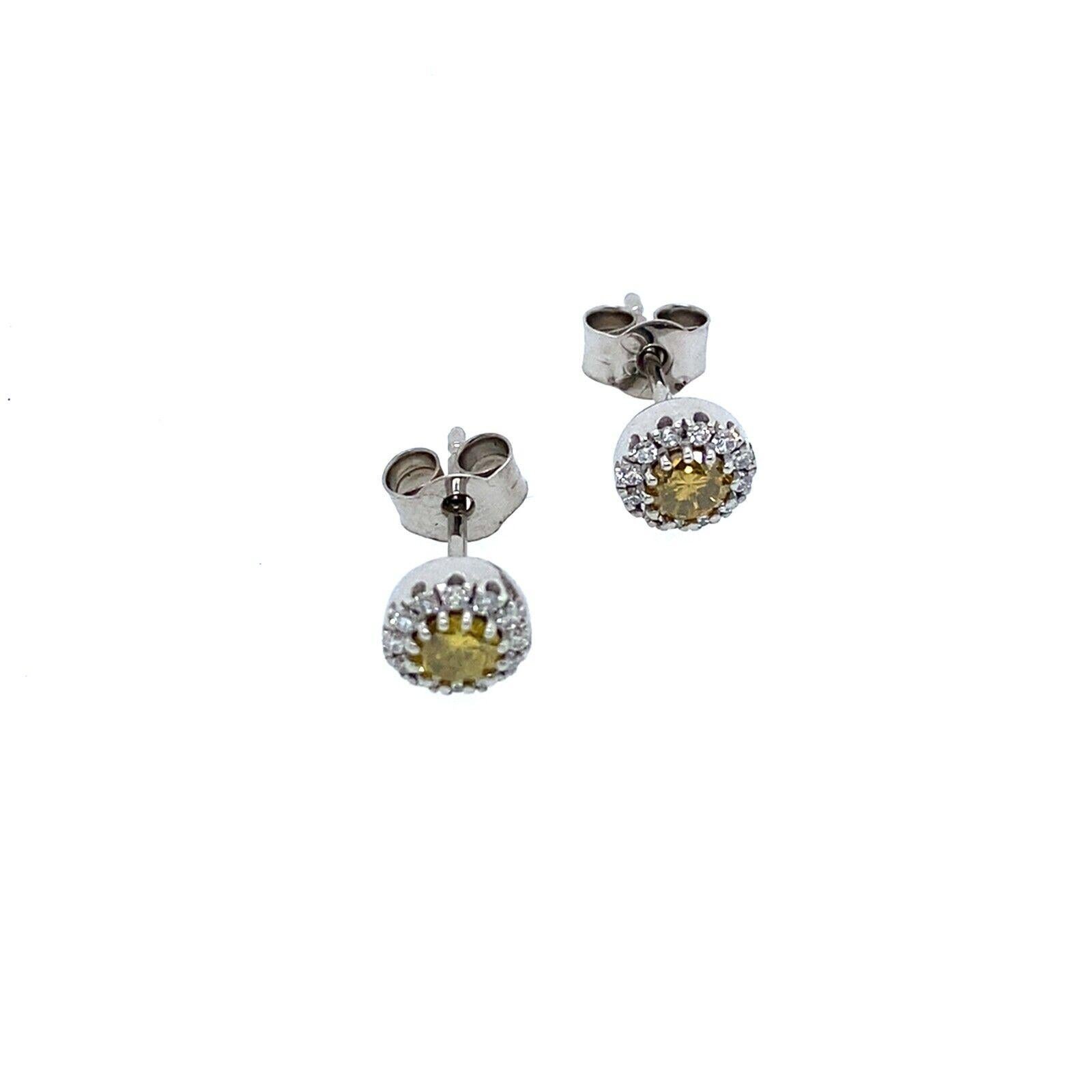 This pair of earrings is set with 2 intense yellow Diamonds that is surrounded by 0.16ct of G/VS white Diamonds. The yellow Diamond is a natural Diamond and the white diamonds are VS diamonds, set in 18ct White Gold and the earrings. With Peg +