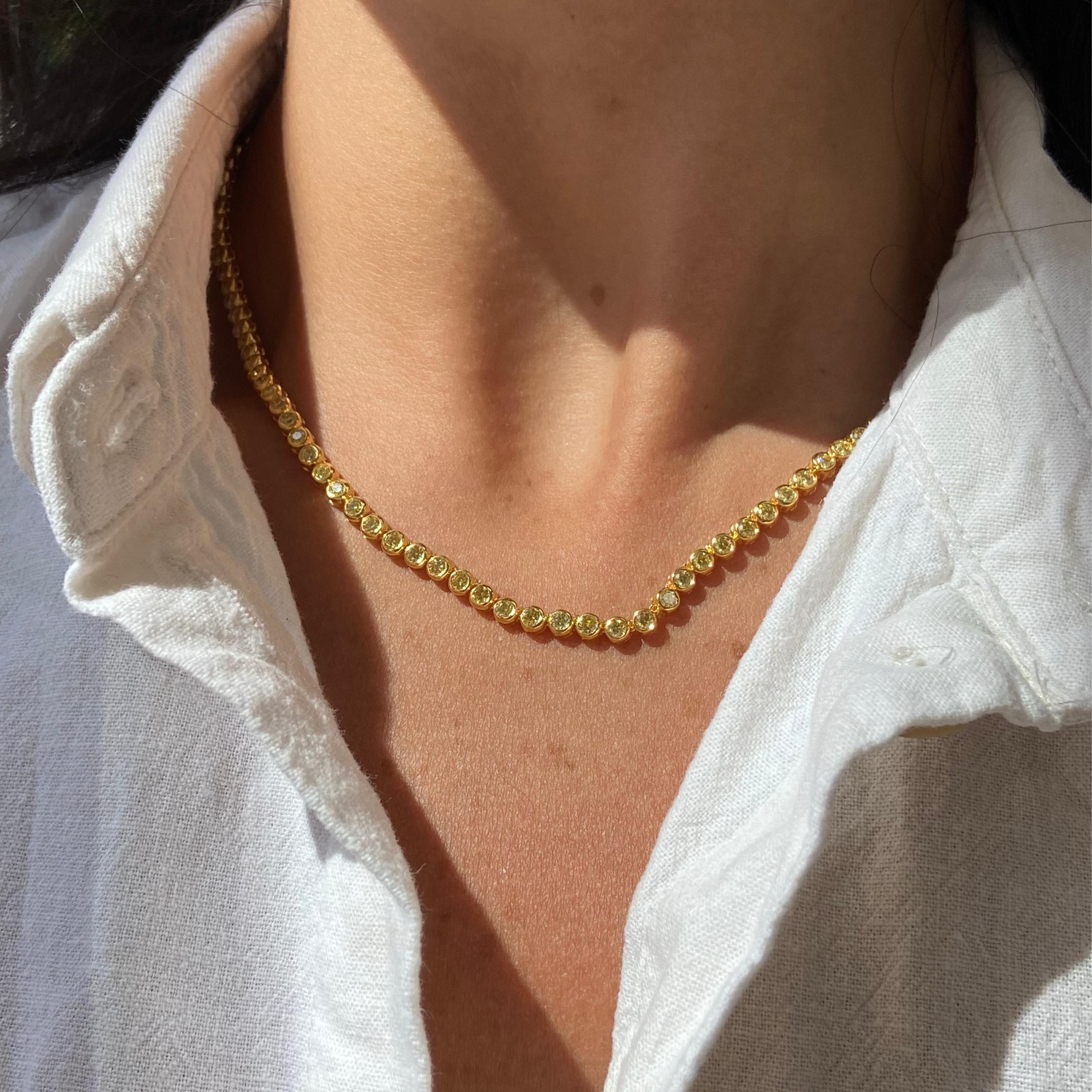 Light up every room with the warm, golden glow of this handcrafted yellow diamond tennis necklace. Featuring approximately 6.30 carats of intense yellow round diamonds, each stone is expertly set in a smooth bezel of 14 karat yellow gold that