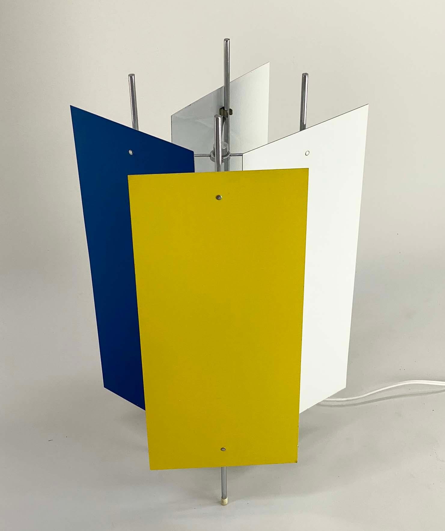Here's a fun lamp from the 1960s in the style of Robert Gage. The lamp consists of a metal framework with an acrylic cylinder that surrounds the light source. There are four enameled aluminum panels that clip to the metal framework and can be