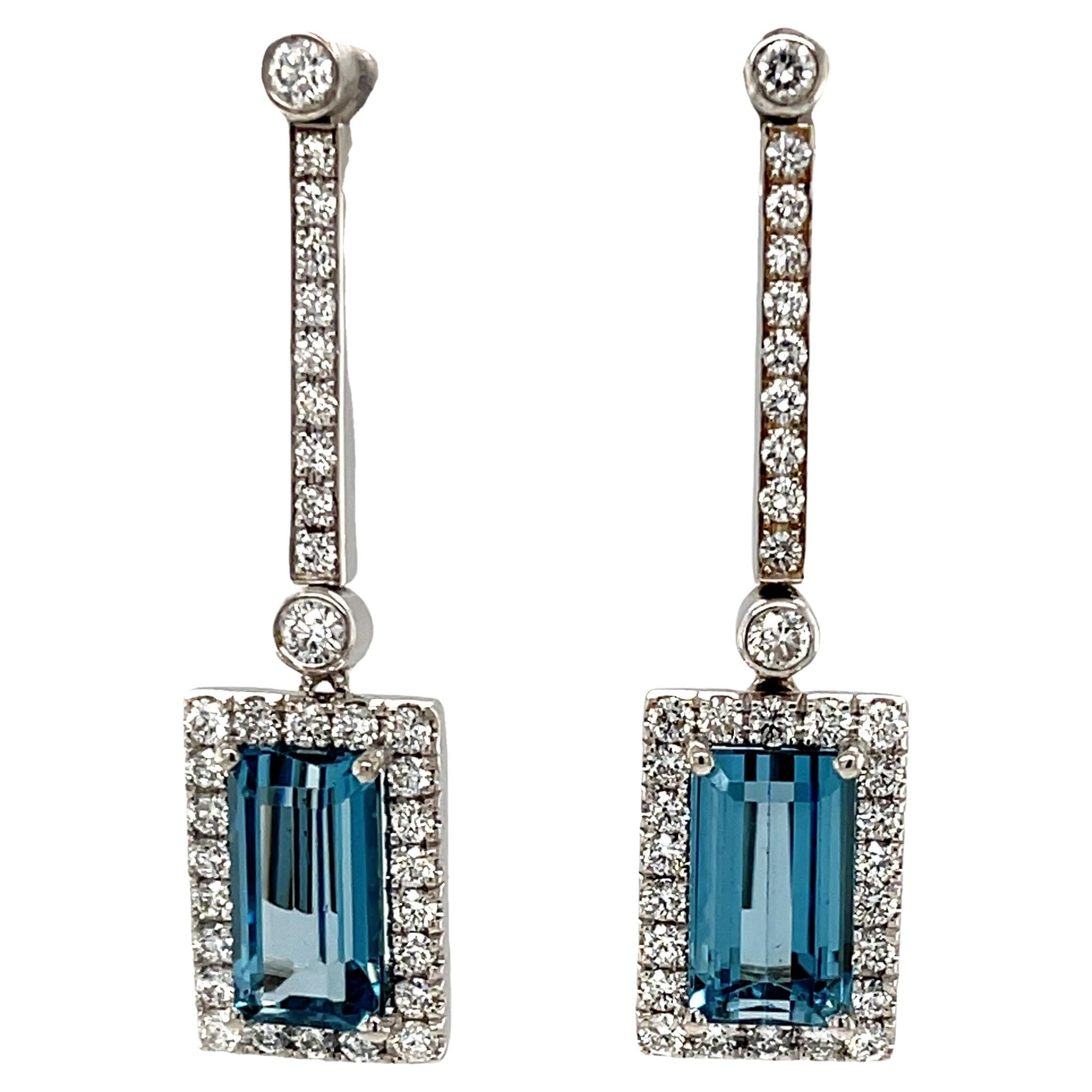 These wonderfully versatile earrings feature gorgeous aquamarine and diamond “drops” suspended from an elegant line of sparkling diamonds! The perfectly matched emerald-cut gems are beautifully crystalline with exceptionally bright, aquamarine blue