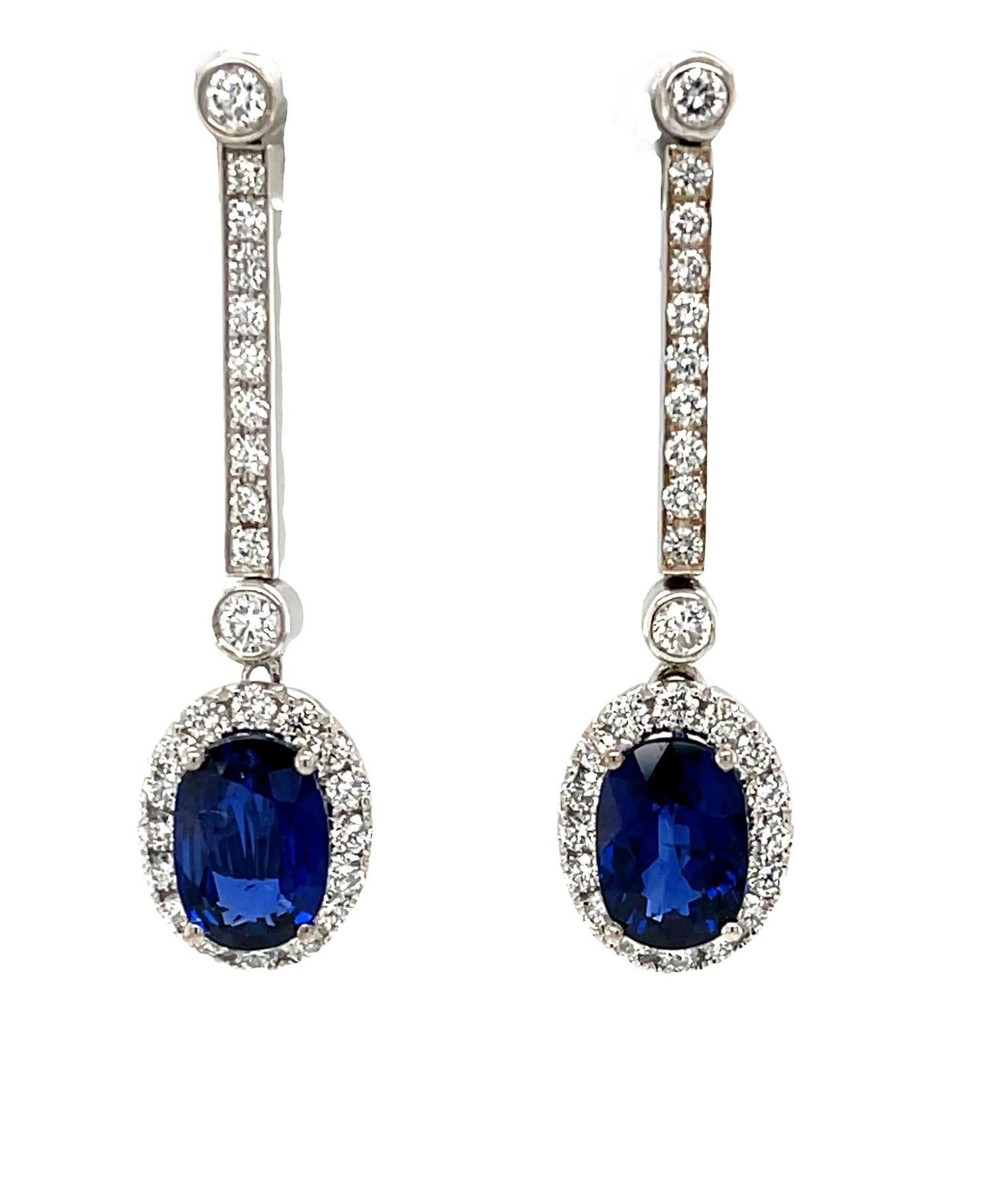 These stunning and beautifully versatile earrings feature brilliant sapphire and diamond drops suspended from an elegant line of sparkling diamonds! The perfectly matched oval sapphires are very fine quality with gorgeous royal blue color. Set in