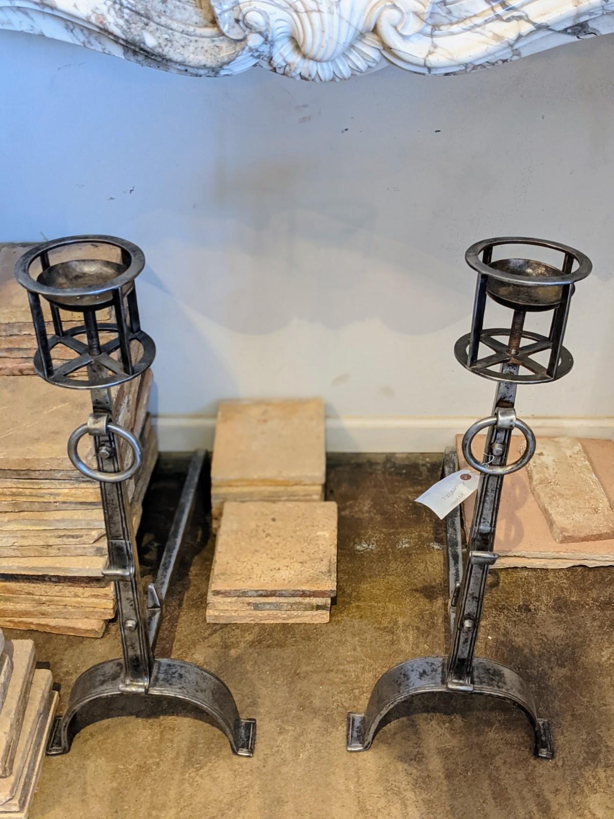 These each feature an adjustable vessel holder atop a tapering ringed standard, having lower and middle outset skewer hooks, ending with bifurcated arched feet. They have a recent polish for an extraordinary patina. These are probably of French
