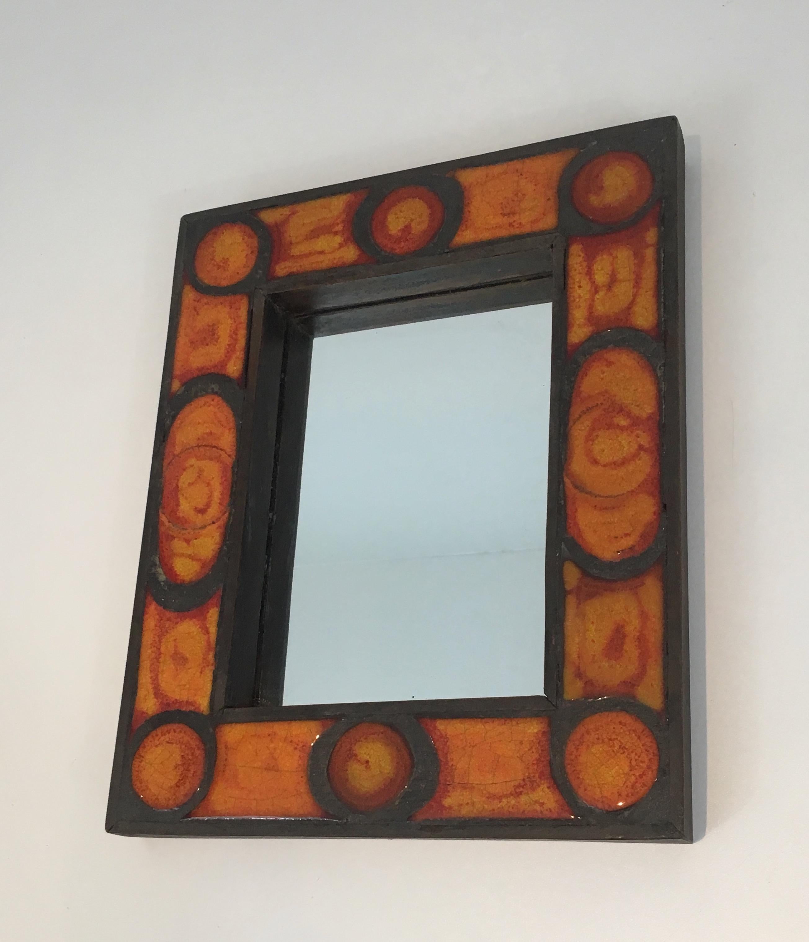 This very nice and interesting small mirror is made of ceramic in the orange tons. This is a very nice French work, circa 1970.