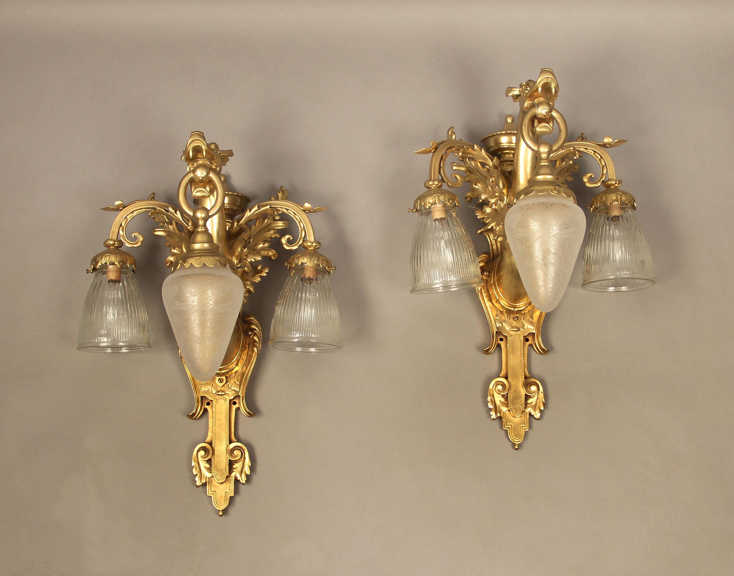 An interesting pair of late 19th century gilt bronze three-light dragon sconces

Each sconce decorated with a female dragon with wings. Three lights, the center one hanging from the dragons mouth with a frosted glass shade.