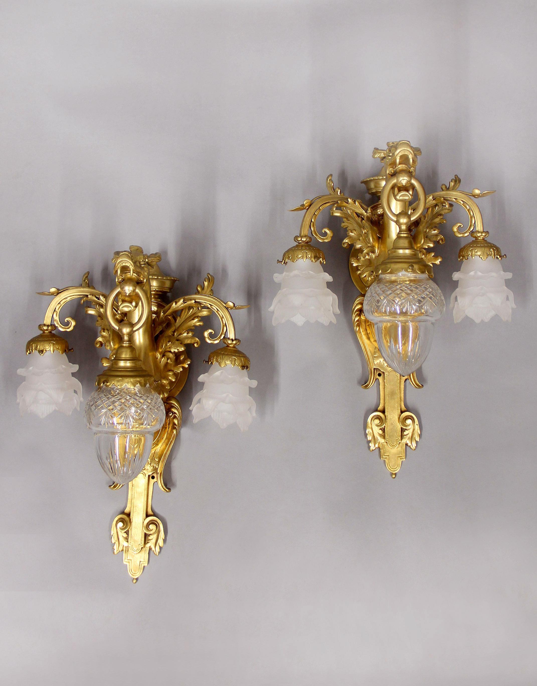Paire intéressante d'appliques à dragon à trois lumières en bronze doré de la fin du XIXe siècle

Chaque applique est décorée d'un dragon femelle avec des ailes. Trois lampes, celle du centre étant suspendue à la gueule du dragon avec un abat-jour