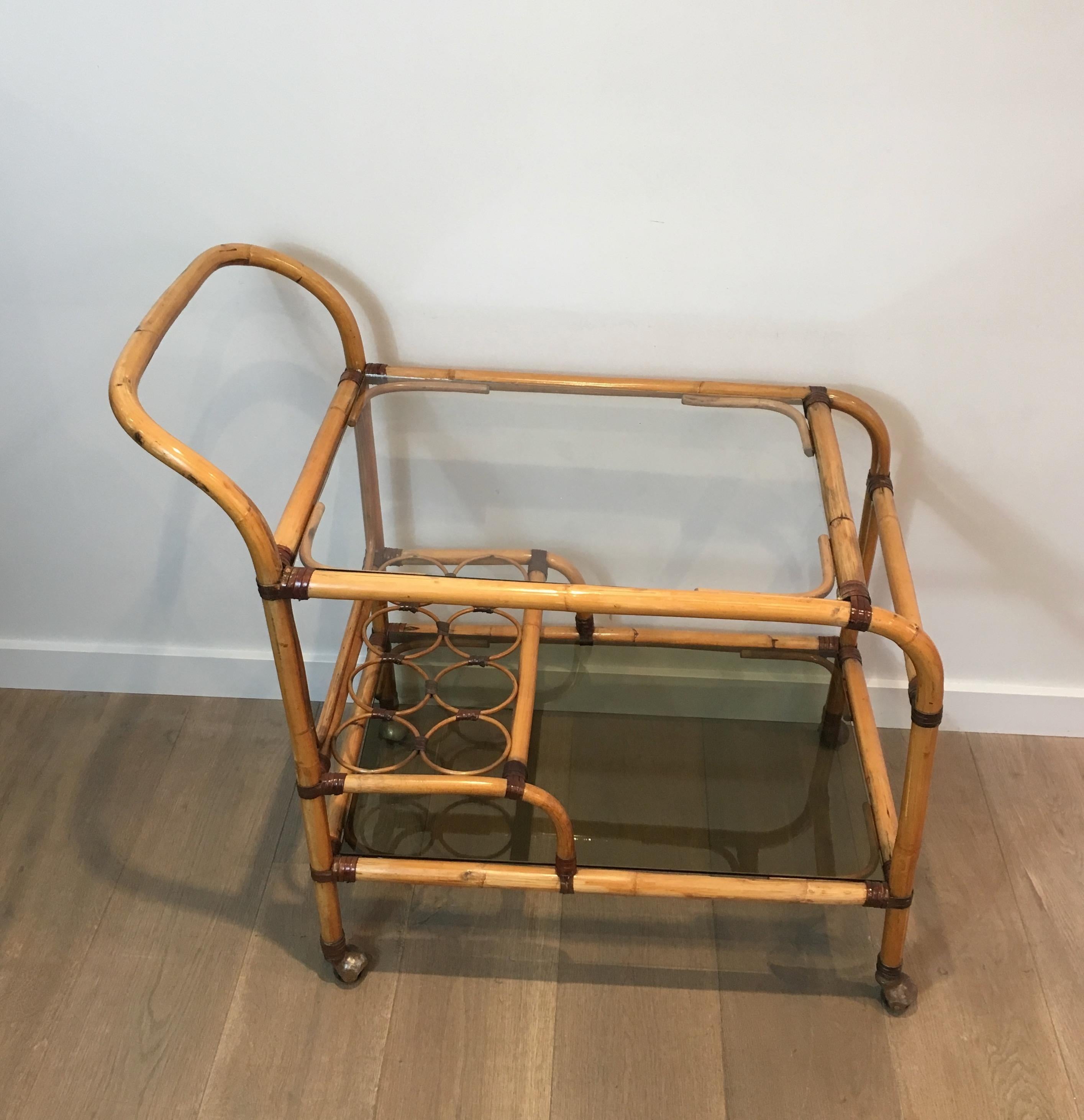 This interesting and unusual drinks trolley is made of rattan with leather links. This is a French work, circa 1950.