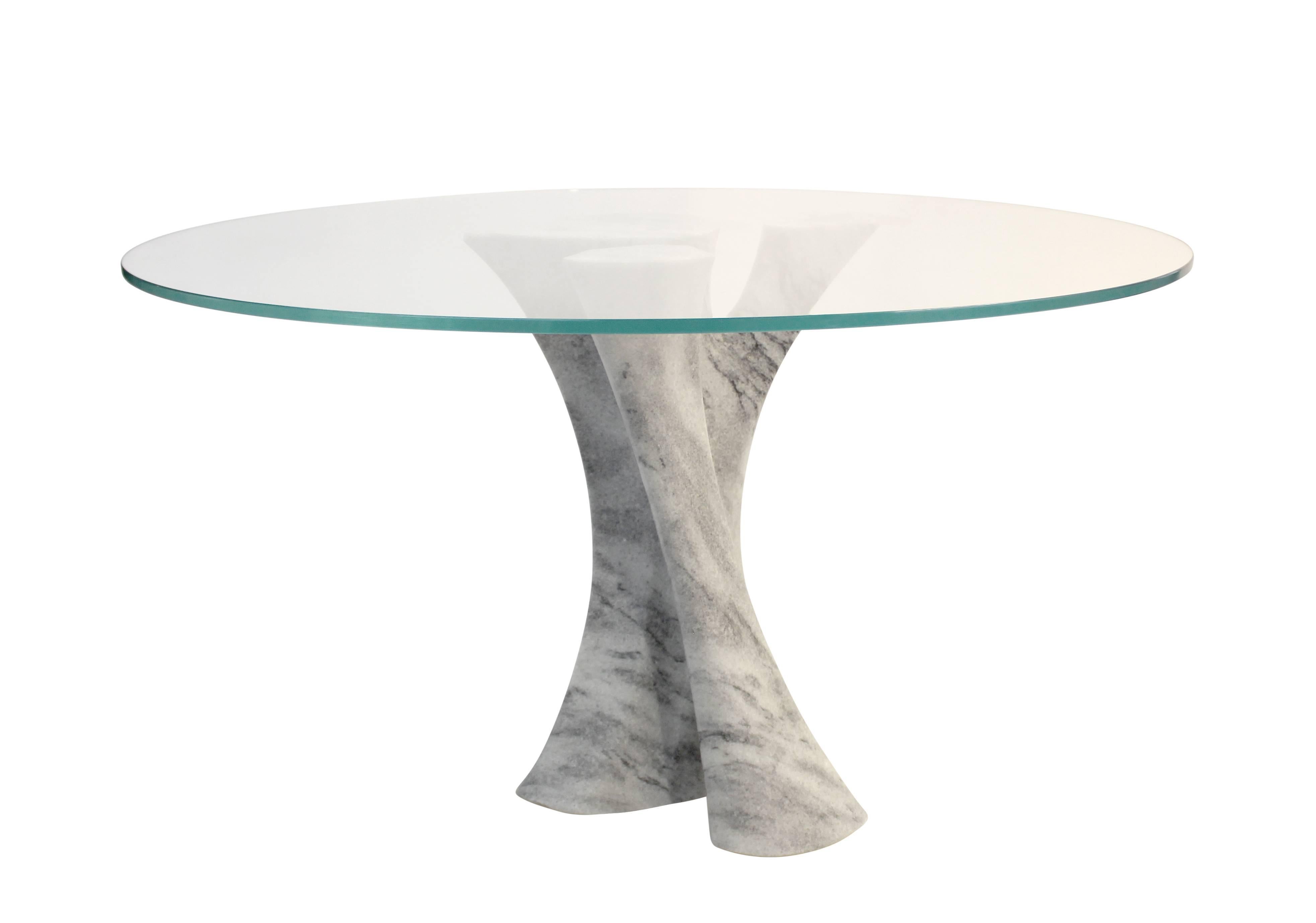 Dramatic leather topped dining table with solid carved stone pedestal base. Shown here in Georgia marble with a glass top, this piece is also available in a range of custom sizes, shapes, and materials. Choose from a selection of imported Italian