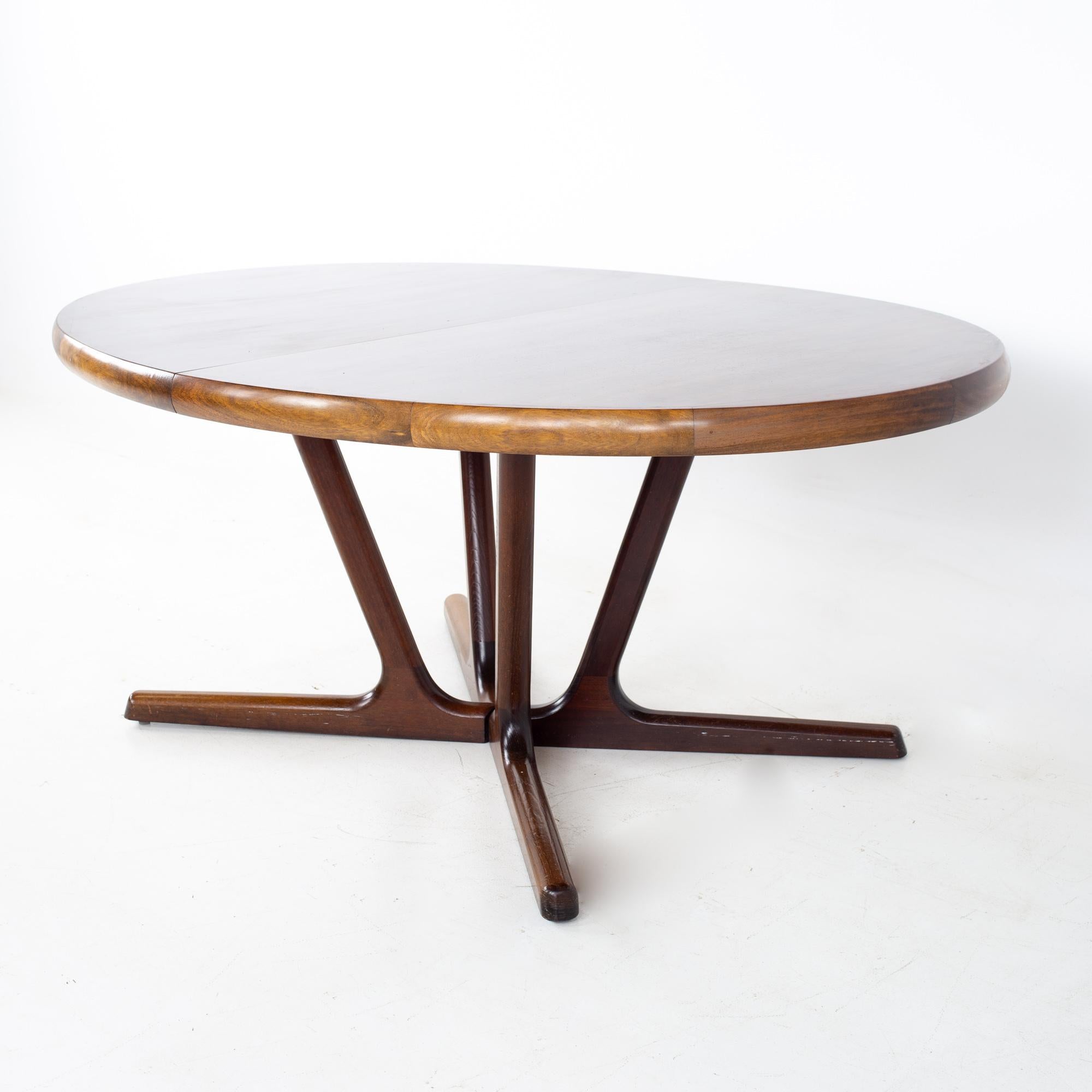 Interform Collection Mid Century Danish rosewood 12 person expanding oval pedestal dining table
Table measures: 68 wide x 47 deep x 27.5 inches high; each leaf is 19.75 inches wide, making a maximum table width of 127.25 when all three leaves are