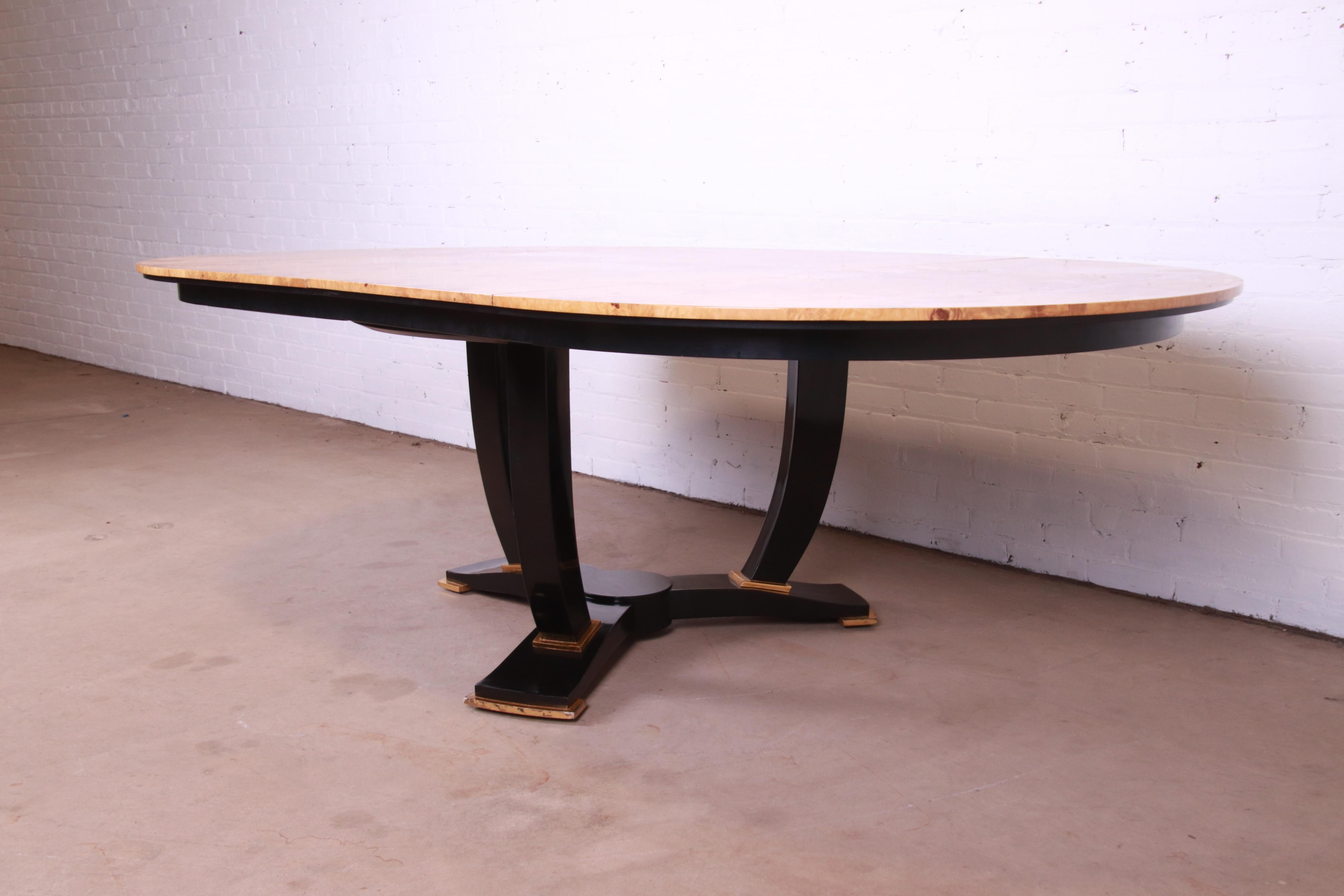 An exceptional modern Art Deco style pedestal extension dining or center table

By Interior Crafts

USA, Circa 1980s

Stunning book-matched burled olive wood top, with black lacquered and giltwood pedestal.

Measures: 54