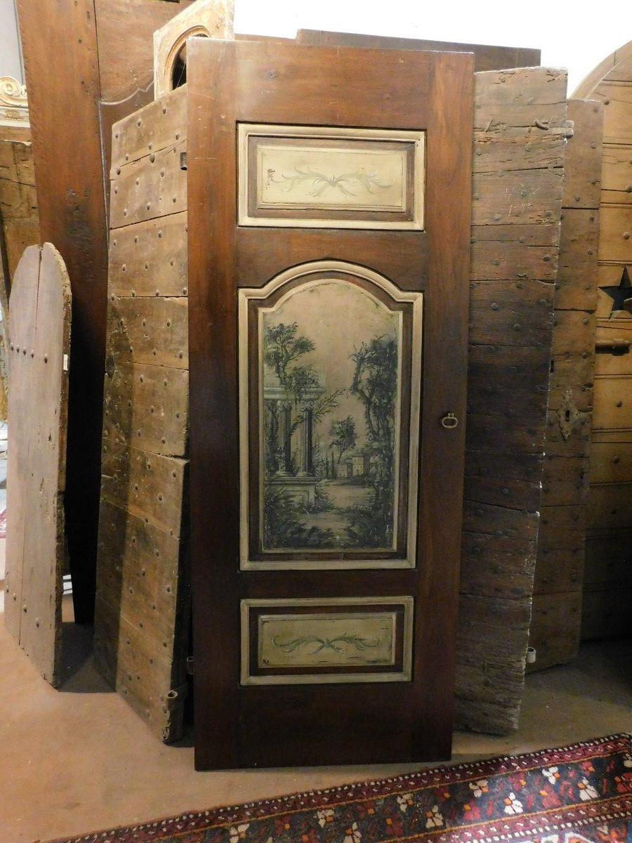 Antigua puerta de interior, de una sola hoja de nogal, ricamente acabada con paneles pintados, paneles tallados y pintados con paisaje, de doble cara: parte posterior también tallada, originaria de Italia (Florencia) y original del siglo XVIII.
No