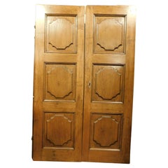 Puerta interior de dos hojas en nogal con paneles tallados, Italia