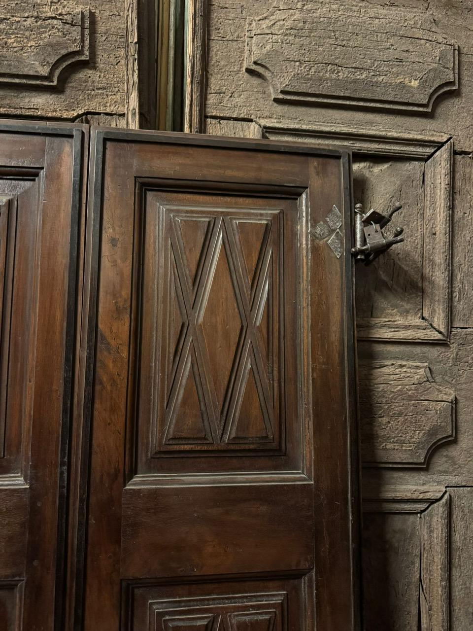 Interior double-leaf walnut door, panels carved with geometric shapes, Italy In Good Condition For Sale In Cuneo, Italy (CN)