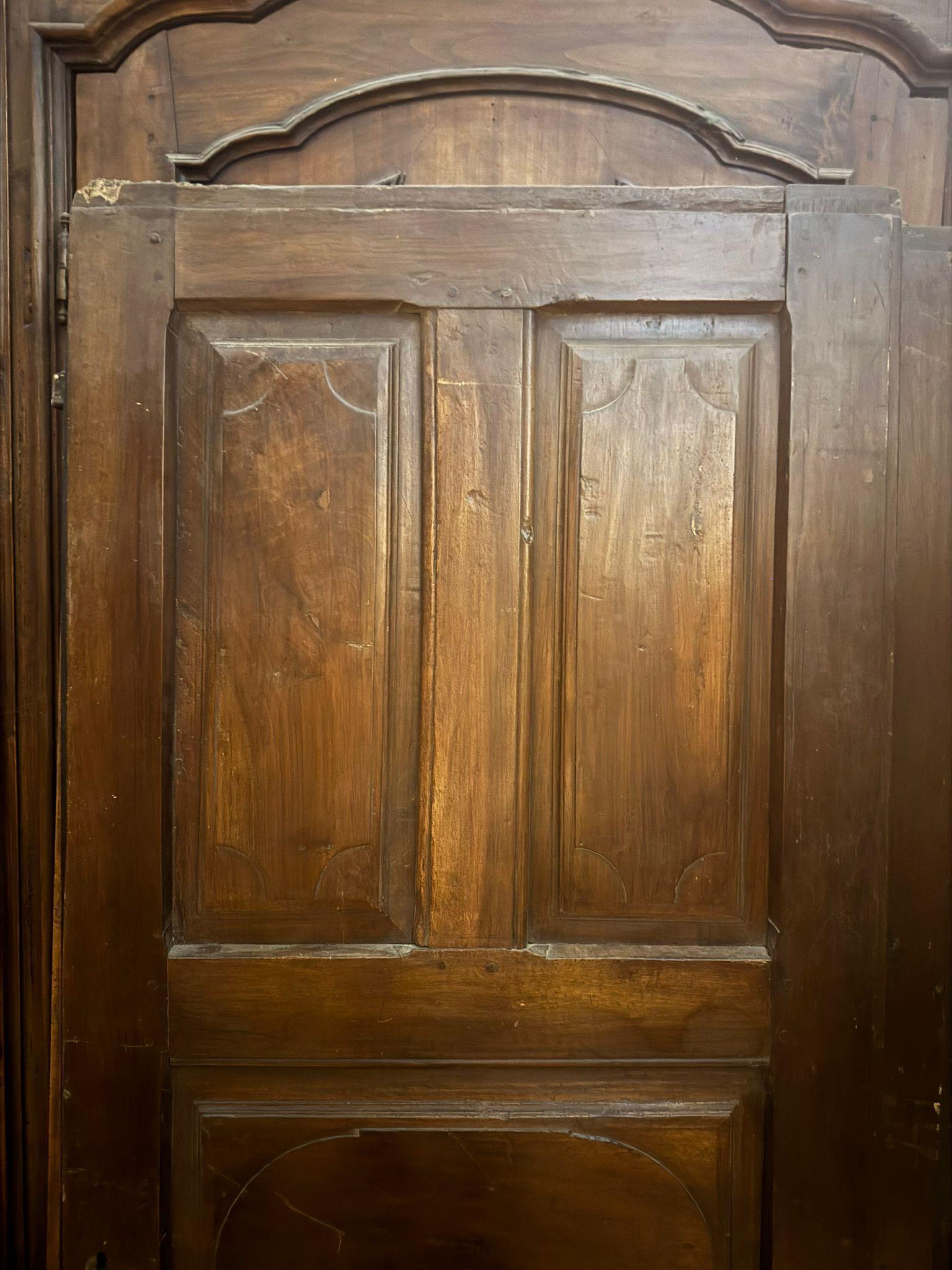 Antique walnut interior door with 5 carved panels. Solid walnut interior door without hinges, so it can also be used as a panel or sliding door. Original from the 18th century, from Italy. Maximum dimensions: 73 x 189 cm.