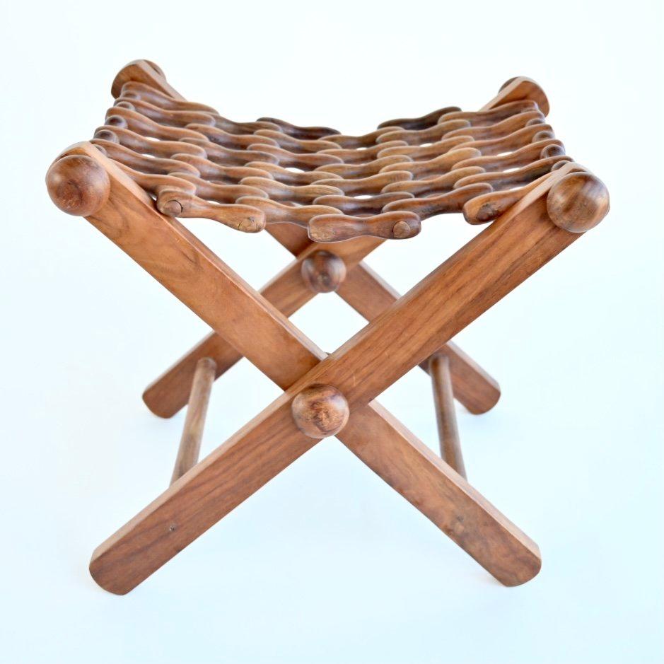 Unique interlocking wood folding stool featuring a beautiful interlocking seat and solid wood frame. USA, mid 20th century