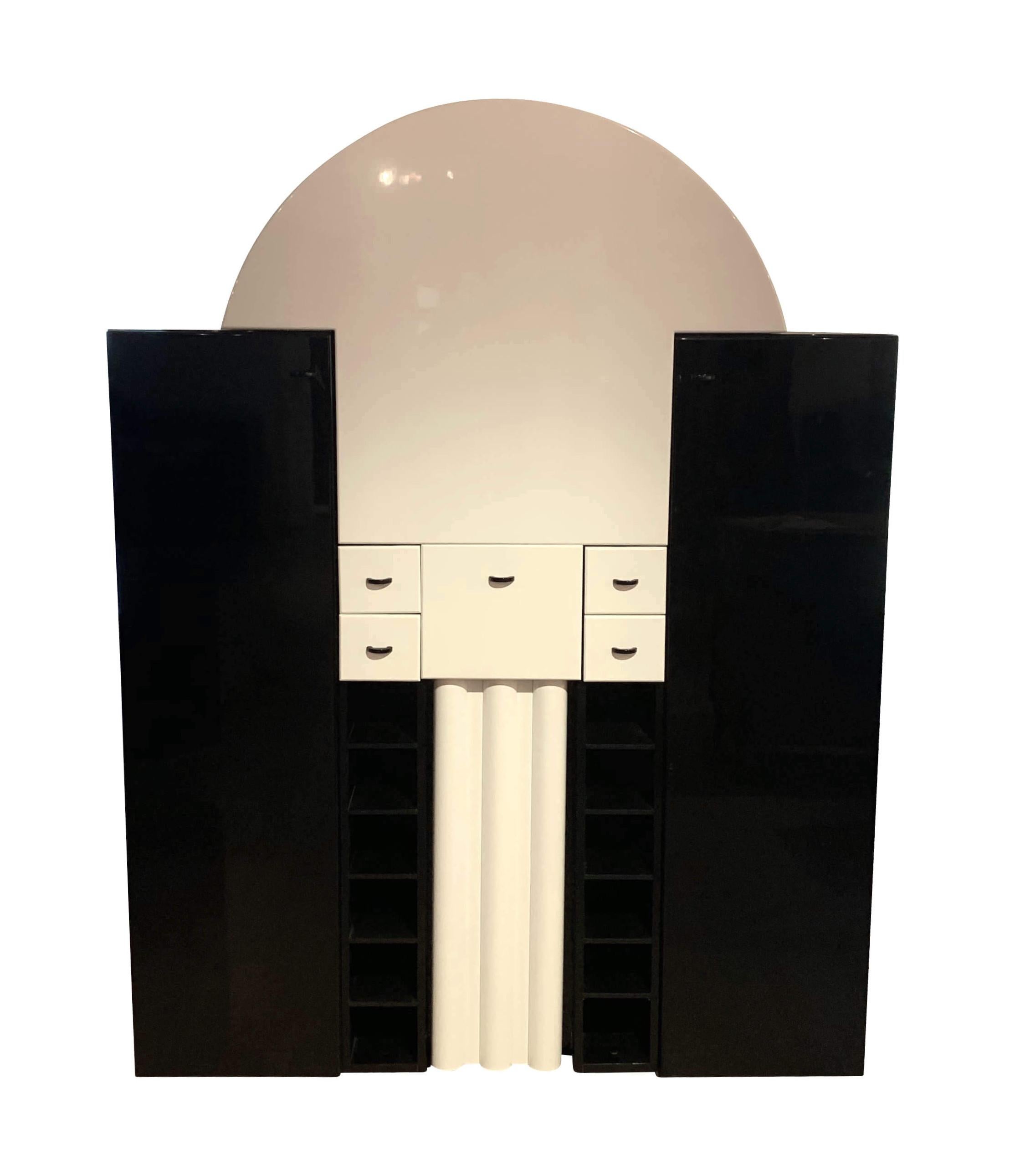 Extravagant bar cabinet from German Manufacturer Interlübke, produced in the 1970s.

Expandable shelf plate, which can be either horizontally folded down on a pull-out column on rolls or attached vertically hold by magnets.

Inside the top arc,