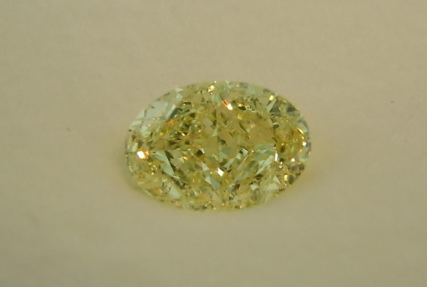 Gia Certified Classic Ring features an 1.71 carat Fancy Light Yellow Oval Diamond with GIA certificate see picture for details of the stone). The center diamond is accompanied by two white trillion  cut diamonds.The mounting is  18 karat white and