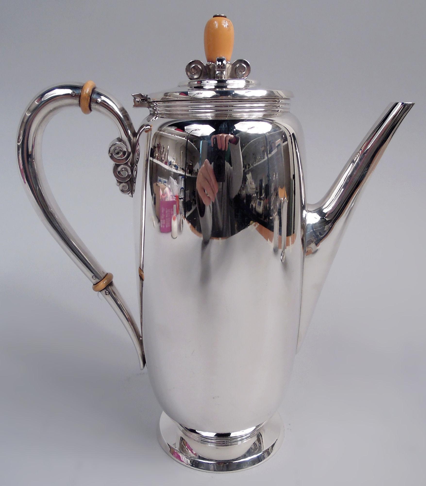 Northern Lights sterling silver coffee set, ca 1930. This set comprises coffeepot, creamer, and sugar. Coffeepot and creamer curved and tubular. Coffeepot has high-looping handle and diagonal spout. Creamer has helmet mouth. Sugar has curved bowl.