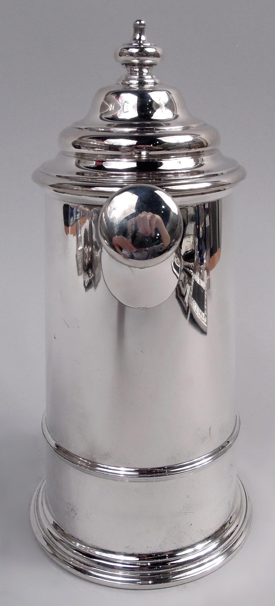 Cocktail-Shaker aus Sterlingsilber im Kolonialstil. Hergestellt von International Silver Co. in Meriden Britannia, Conn. um 1920. Gegürteter und sich nach oben verjüngender Zylinder mit gespreiztem und gestuftem Sockel; Rollgriff und stumpfer