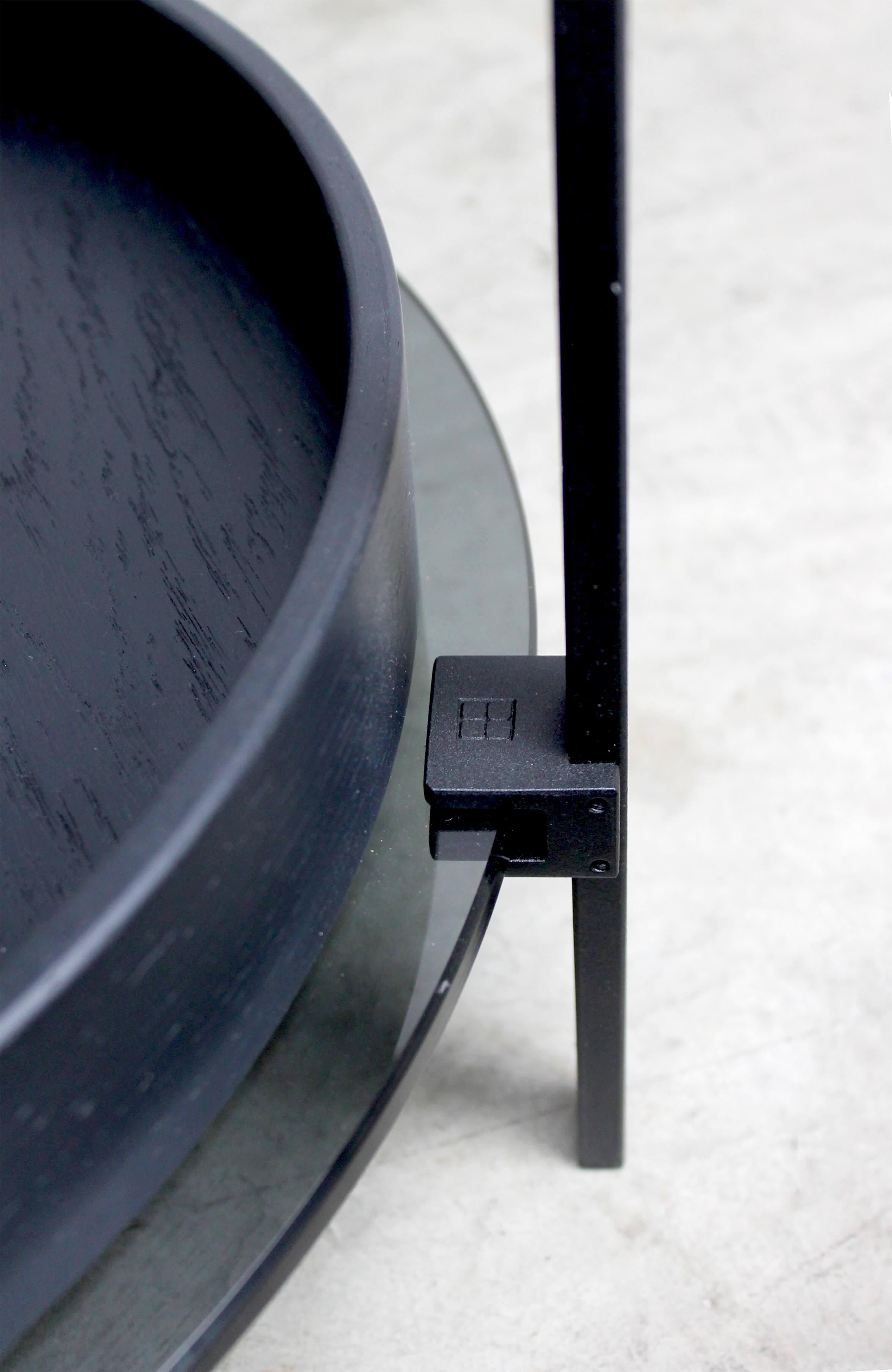 This mid century modern minimalist 'Amy' T79DB side table was designed by Peter Ghyczy in 2015 and hand-crafted in the GHYCZY atelier in the South of the Netherlands. The circular minimalist side table features a three-leg black charcoal metal