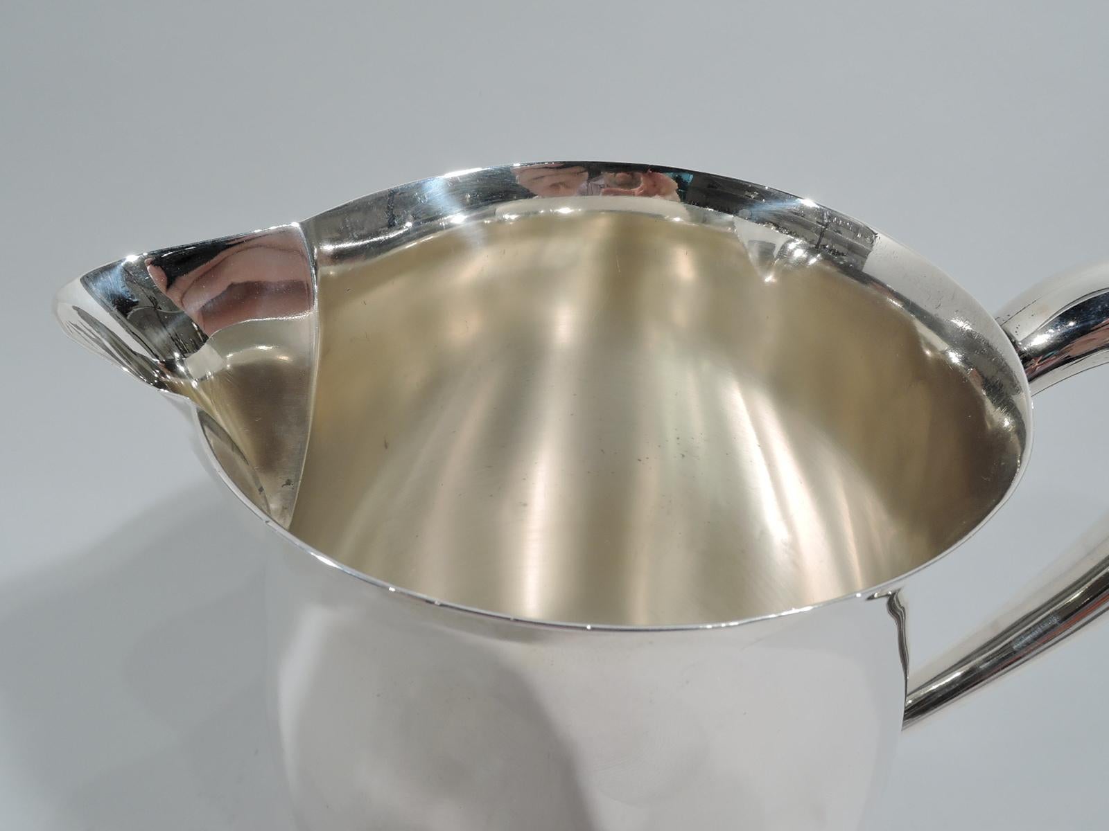 American Federal-style sterling silver water pitcher. Made by International in Meriden, Conn., ca 1950. Curved body with round mouth, v-spout, and high looping handle. Fully marked including maker’s stamp, phrase “Paul Revere / Reproduction”, no.