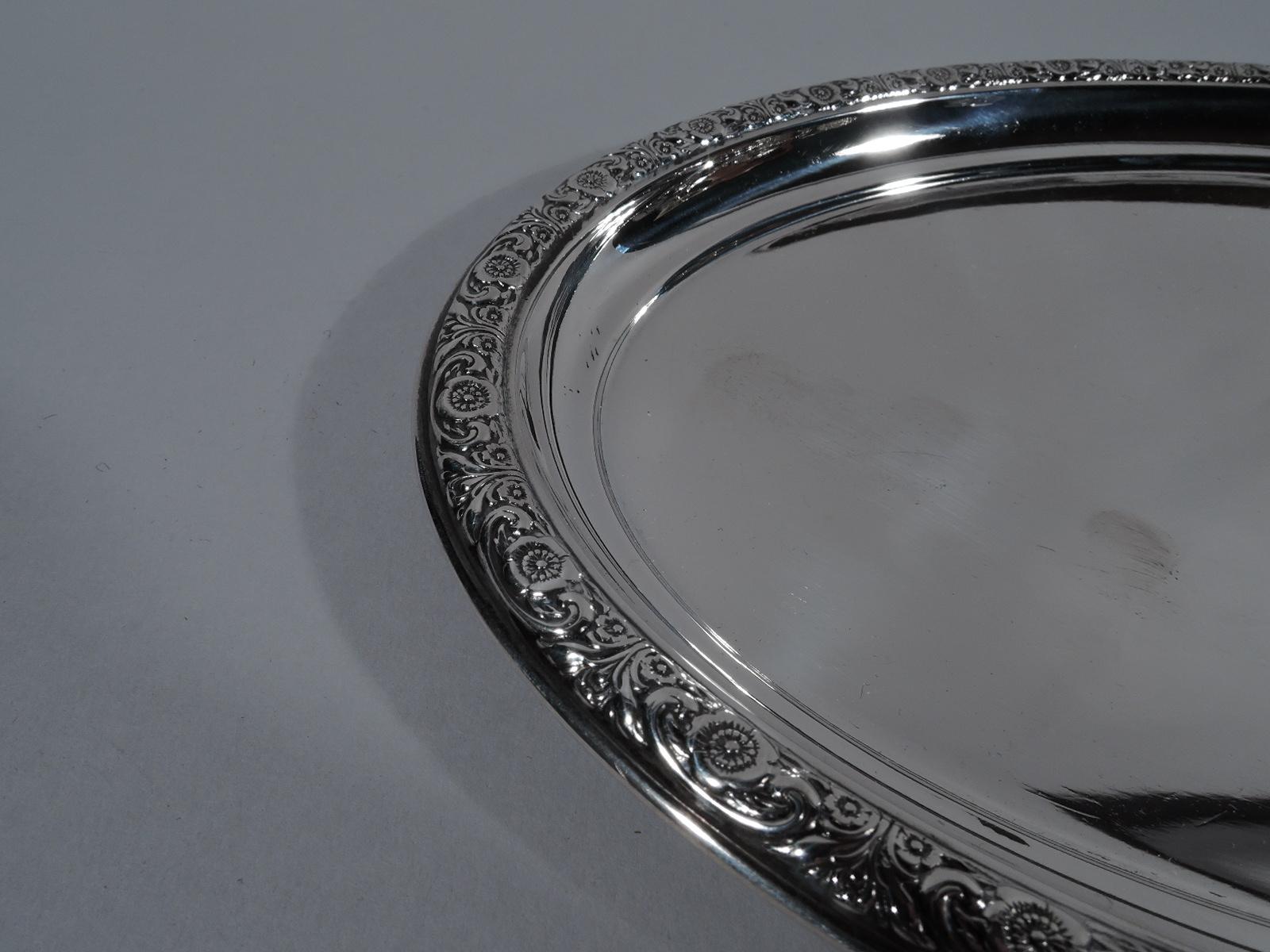 Prelude sterling silver tray. Made by International in Meriden, Conn. Oval. Rim has repousse flowers and scrolls. Fully marked including pattern name and no. W46. Weight: 5 troy ounces.