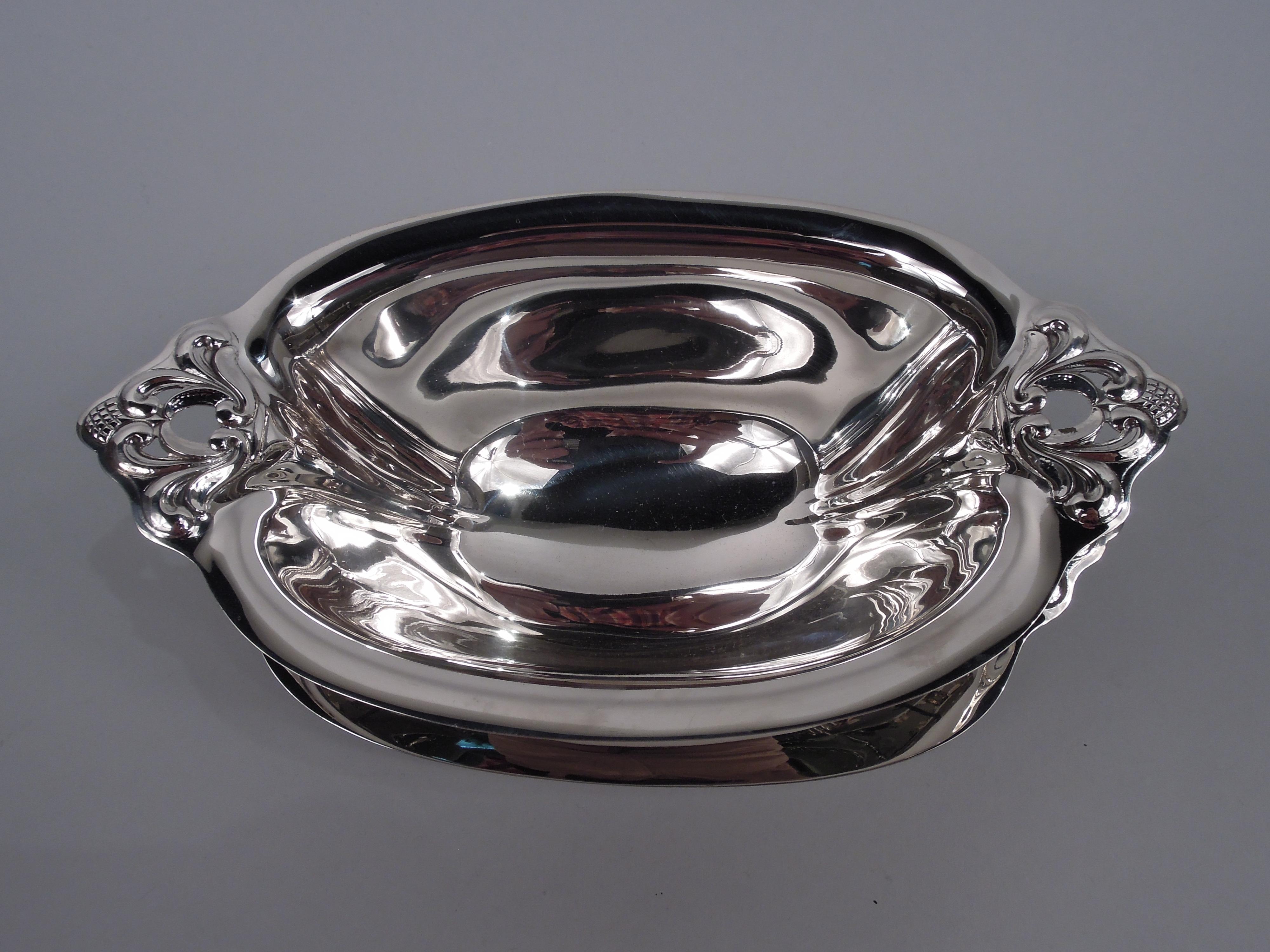 Royal Danish sterling silver sauce bowl on stand. Made by International in Meriden, Conn. Ovoid bowl with tapering sides and short inset foot. Stand has oval well and wide and tapering sides. At ends are open and embossed acorns and scrolls. Fully