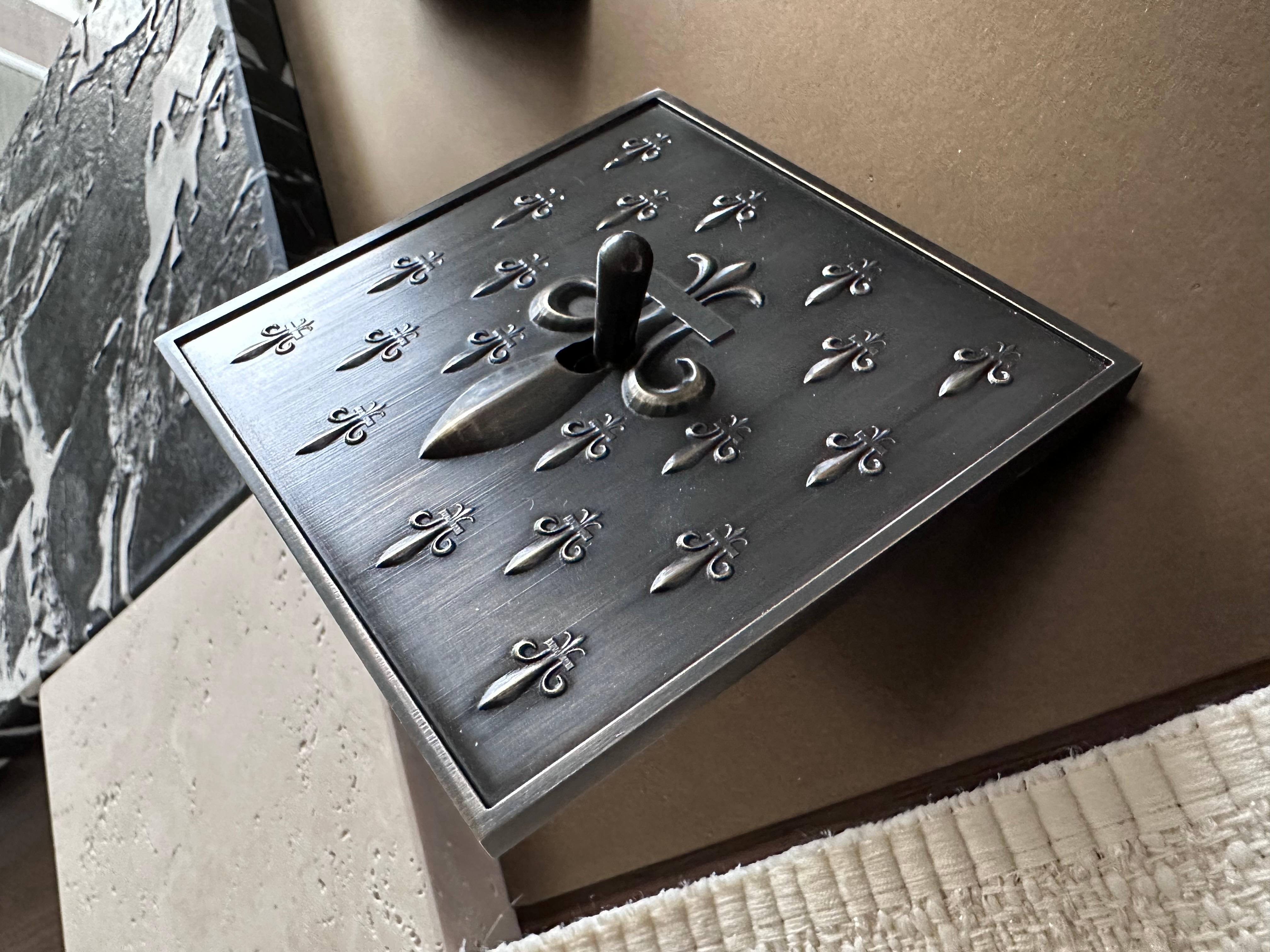 Fleur de Lys Versailles collection switch by Jerome Bugara.
Handcrafted by the art bronzier Rémy Garnier (France).

In brass with dark oxide finish.

Fitting to UK US or EU/FR standards.

Case compatibility to be defined after ordering.