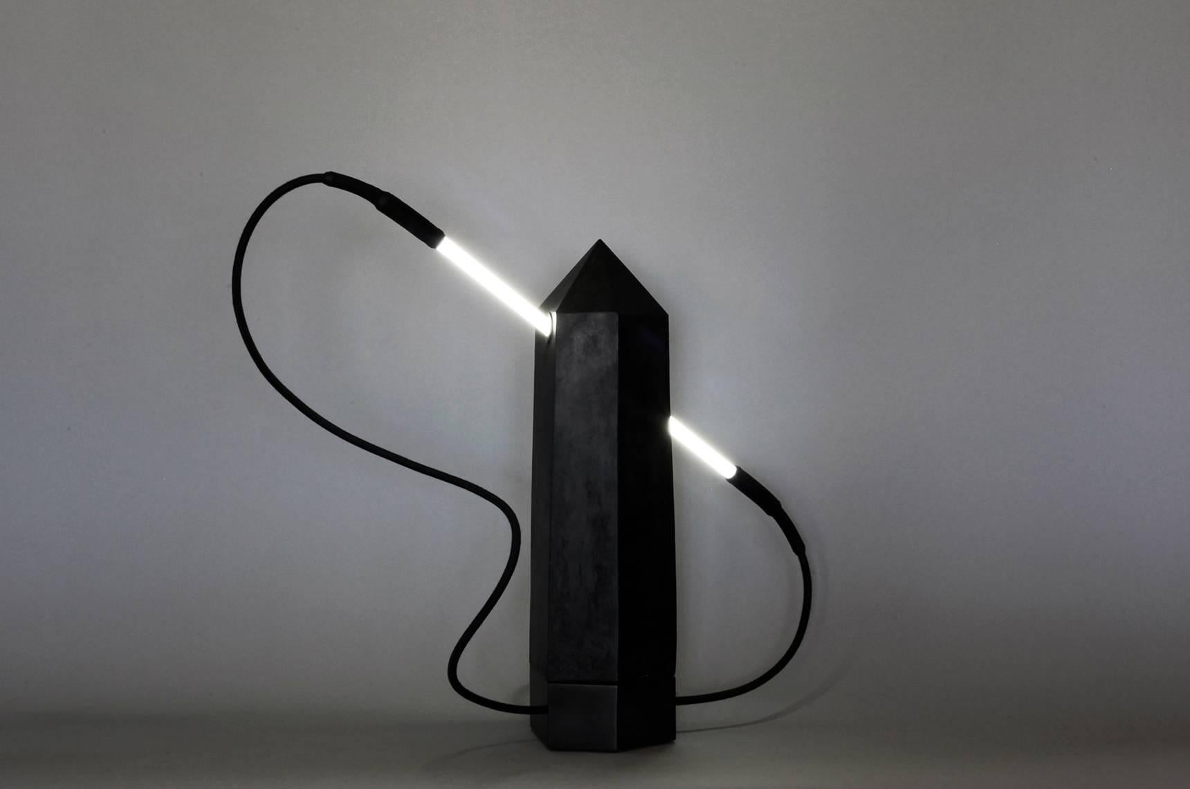 A study of Brutalist architecture in combination with natural elements.
Shungite absorbs electromagnetic energy and by being pierced with healing white light in the form of neon, intersection becomes a study of positive and negative space.
“Shungite