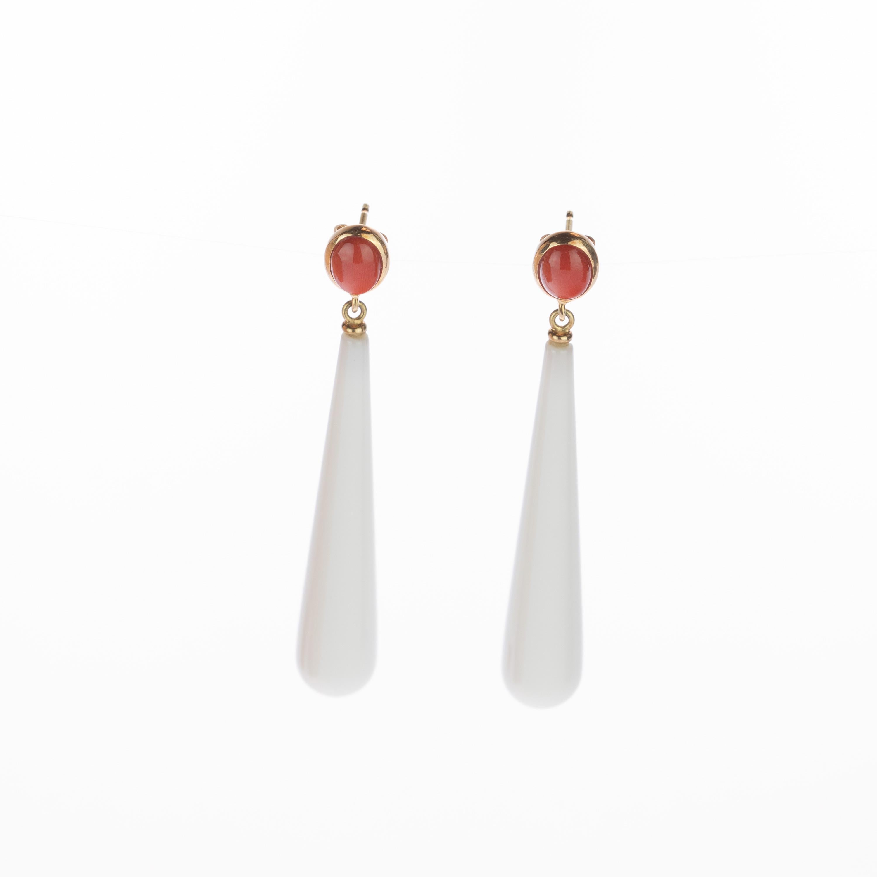 Fresh and youthful white bold white agate teardrop long earrings. Holded by a round mediterranean red coral surrounded by 18 karat yellow gold that recreates a stylish piece of jewelry that can highlight any look. The perfect touch full of modernity